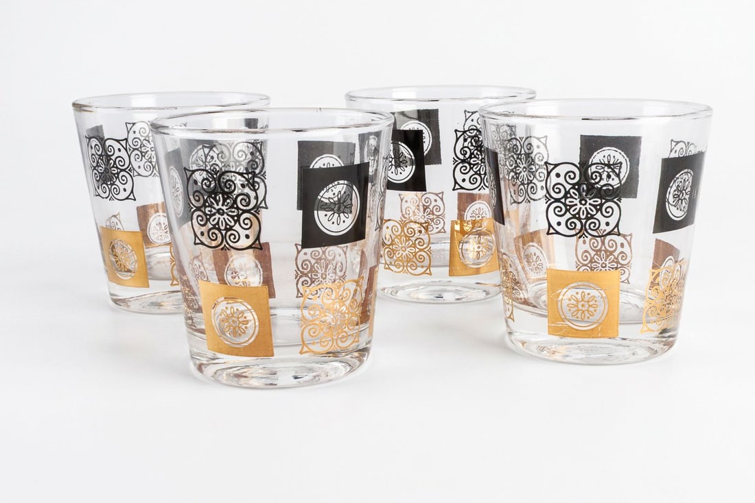 Vintage MCM Medallion Tumblers: Four vintage MCM black and gold medallion decorated tumblers. Some minor scratches present on the print. Please see photos for more details.