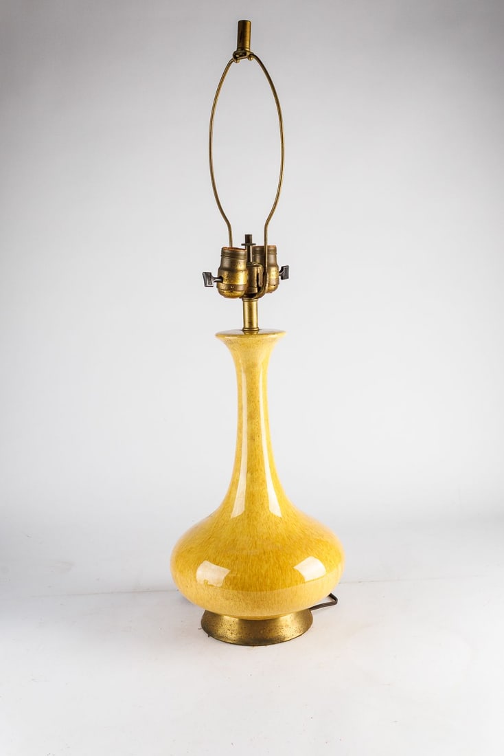 Vintage MCM Ceramic Table Lamp in Mustard Yellow Glaze: This vintage mid-century modern table lamp is treated with a vibrant, mustard-yellow glaze that beautifully accentuates its bulbous, ceramic body and slender neck. A tall shade harp with brass finial