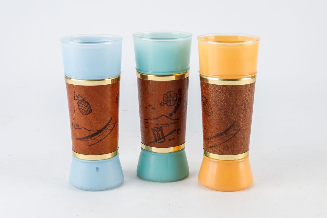 Vintage Siesta Ware Tiki Glasses: Vintage Siesta Ware Tiki Glasses. This trio features a stunning mix of pastel frosted colors and beautifully detailed mahogany wood jackets and brass tone bands. The wooden sleeve on the light blue