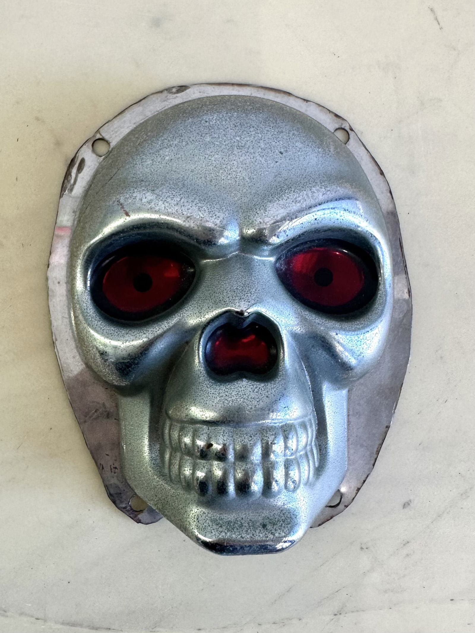 Vintage Boho Metal Skull with Red Eyes: A metal sculpture of a skull with red eyes.
