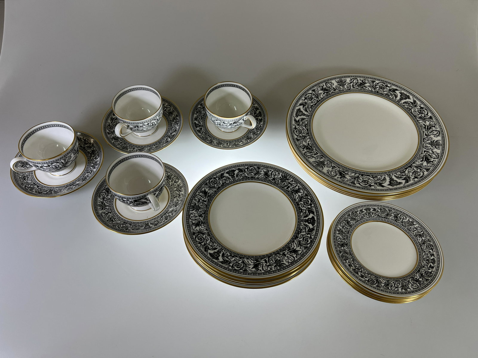 Set of Wedgwood Florentine Black & Gold Dragon Desert (20 PCS): Wedgwood Florentine (W4312) Bone China, made in England. Place settingsfor 4 total 20 pieces. All pieces have black on white intricate dragon design with gold to rim and center. The Florentine pattern