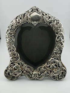 1895 William Comyns & Sons Sterling Silver Table Mirror: 1895 William Comyns & Sons Sterling Silver Table Mirror. The bevelled heart shape mirrorplate with a sterling lattice surround with love birds, flowers and grotesque masks, fitted with an easel suppor