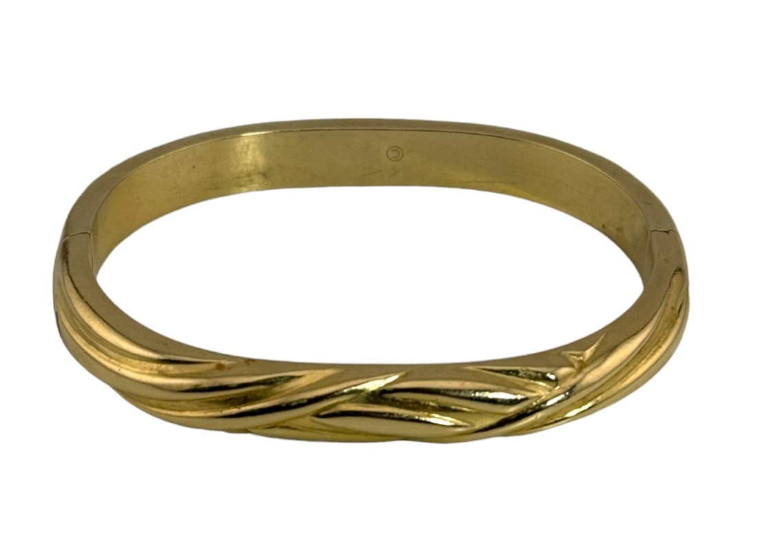 14K Twisted Oval Shaped Hollow Bangle.: Oval shaped hollow 14k bangle. Swirl design, safety closure. 14k, 10grms. Size: 2.75 x 3"