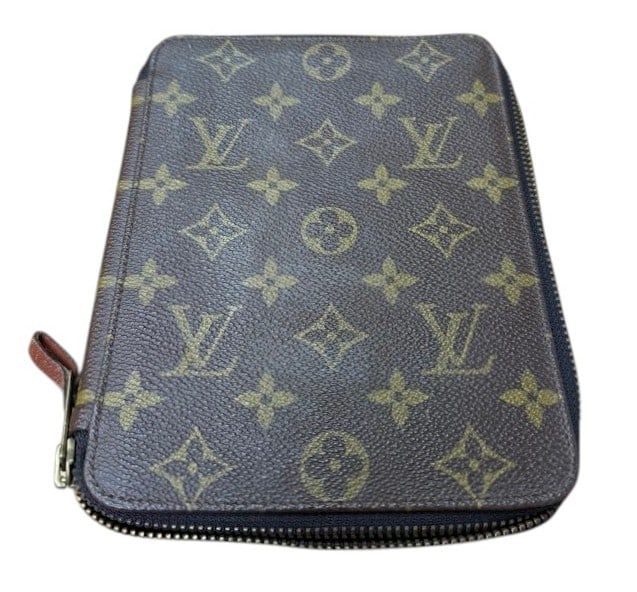 Louis Vuitton Zippy Agenda Cover: Louis Vuitton Zippy Agenda Cover. This agenda cover is crafted of classic Louis Vuitton monogram coated canvas. The brass wrap-around zipper opens ths wallet to a brown cross-grain leather interior. C