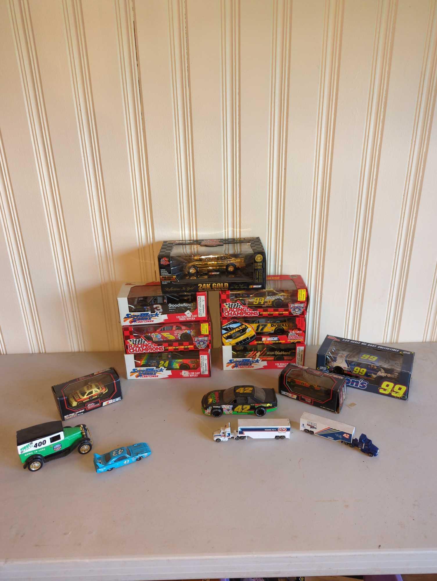 Approx. 15 NASCAR Racing Champions 1:24 Scale Die Cast Cars, 1:64 Scale Die Cast Transporters and: Several NASCAR 1:24 die cast cars, 1:64 scale die cast team transporters and more, see photos for all included.