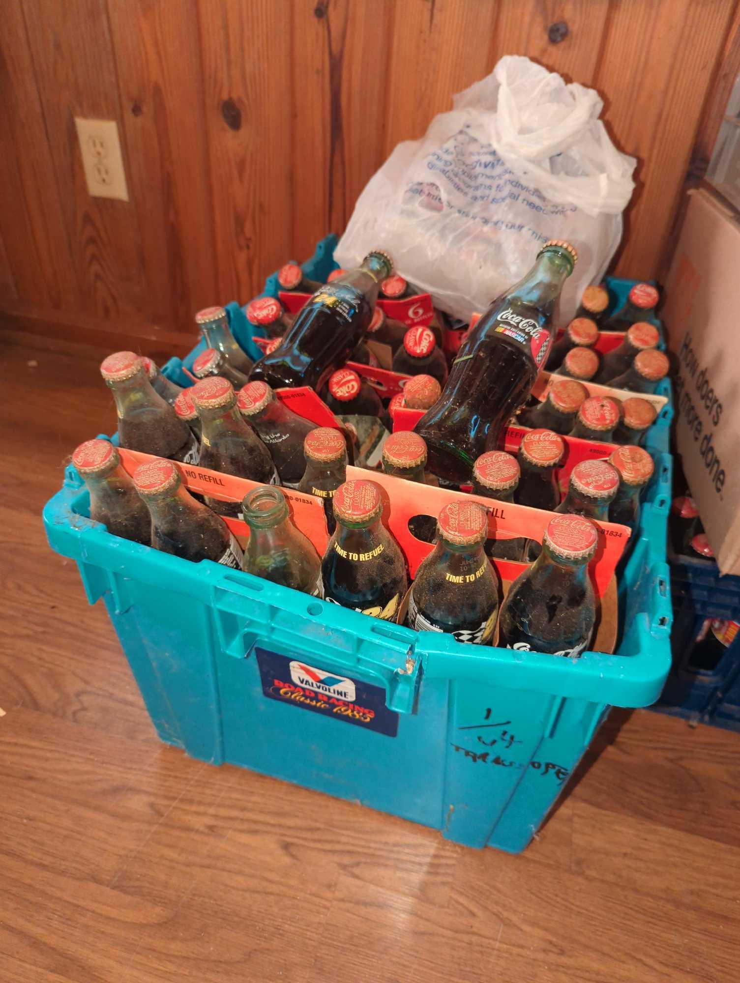 Coca Cola Bottles: Most are unopened and full of cola.