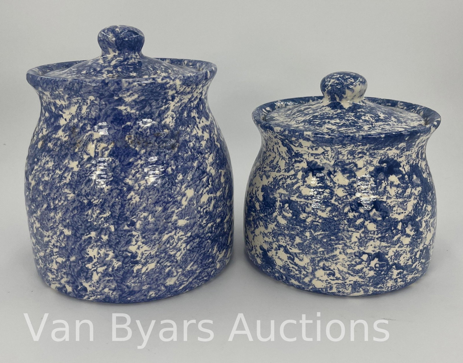 Pair of Blue and White Spongeware Canisters, INV. 2018: Approx. height of tallest to top of lid 8 1/4". With chip to lid of tallest cannister.