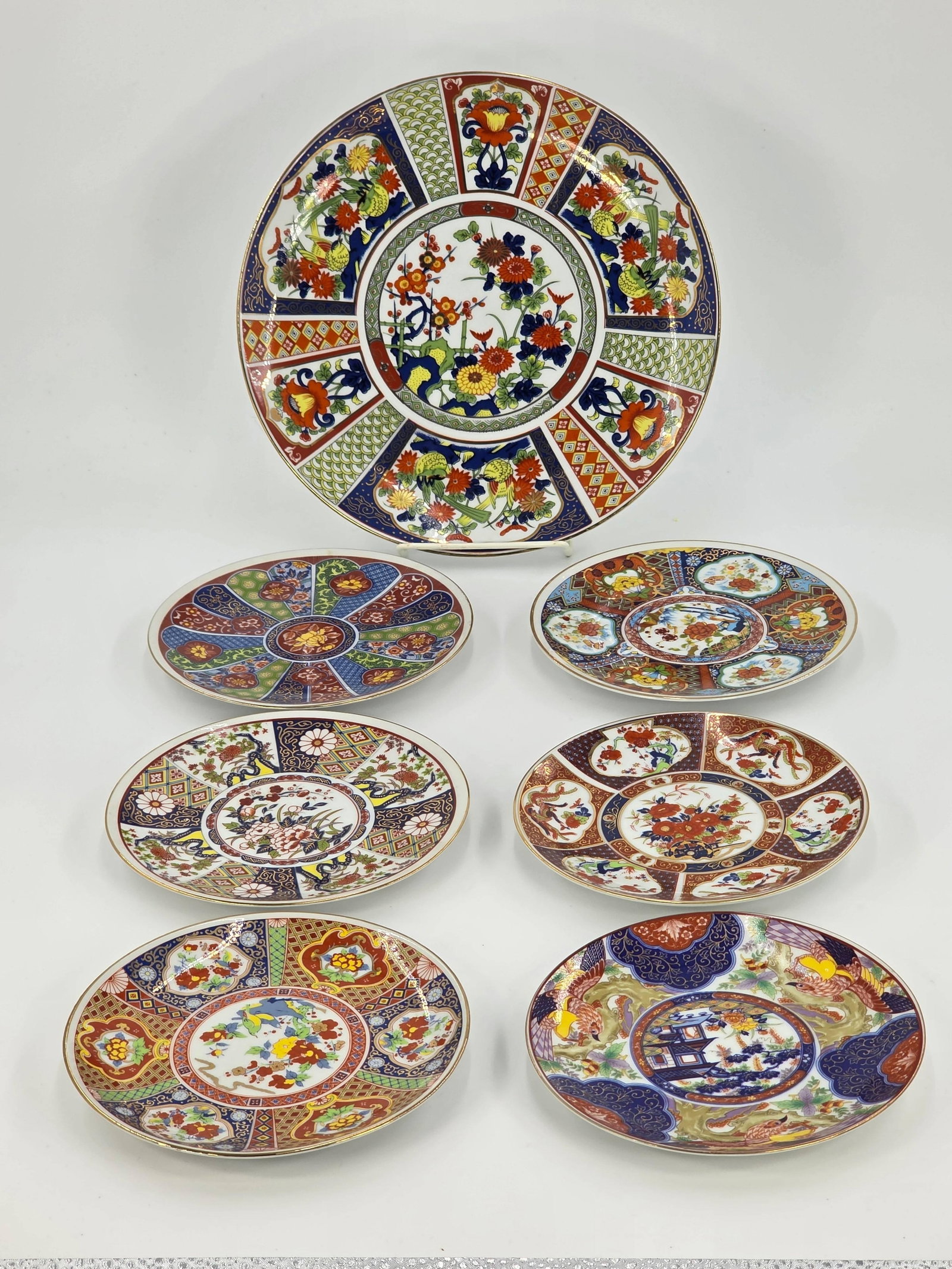 Seven Japanese Imari Plates, INV. 1101: Largest plate dia. approx. 10 1/8". Small plates with markings.