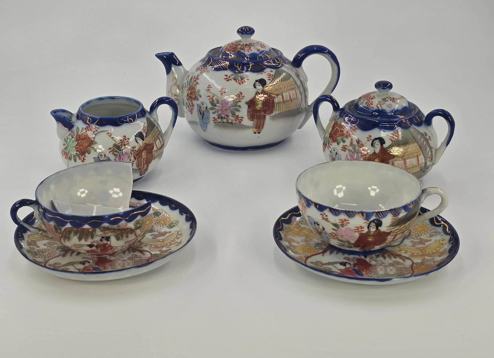 Japanese Geisha Tea Set, INV. 1027: 9 pieces including lids. 4 5/8" approx height of teapot to top of lid 5 1/2" plate dia. With markings.