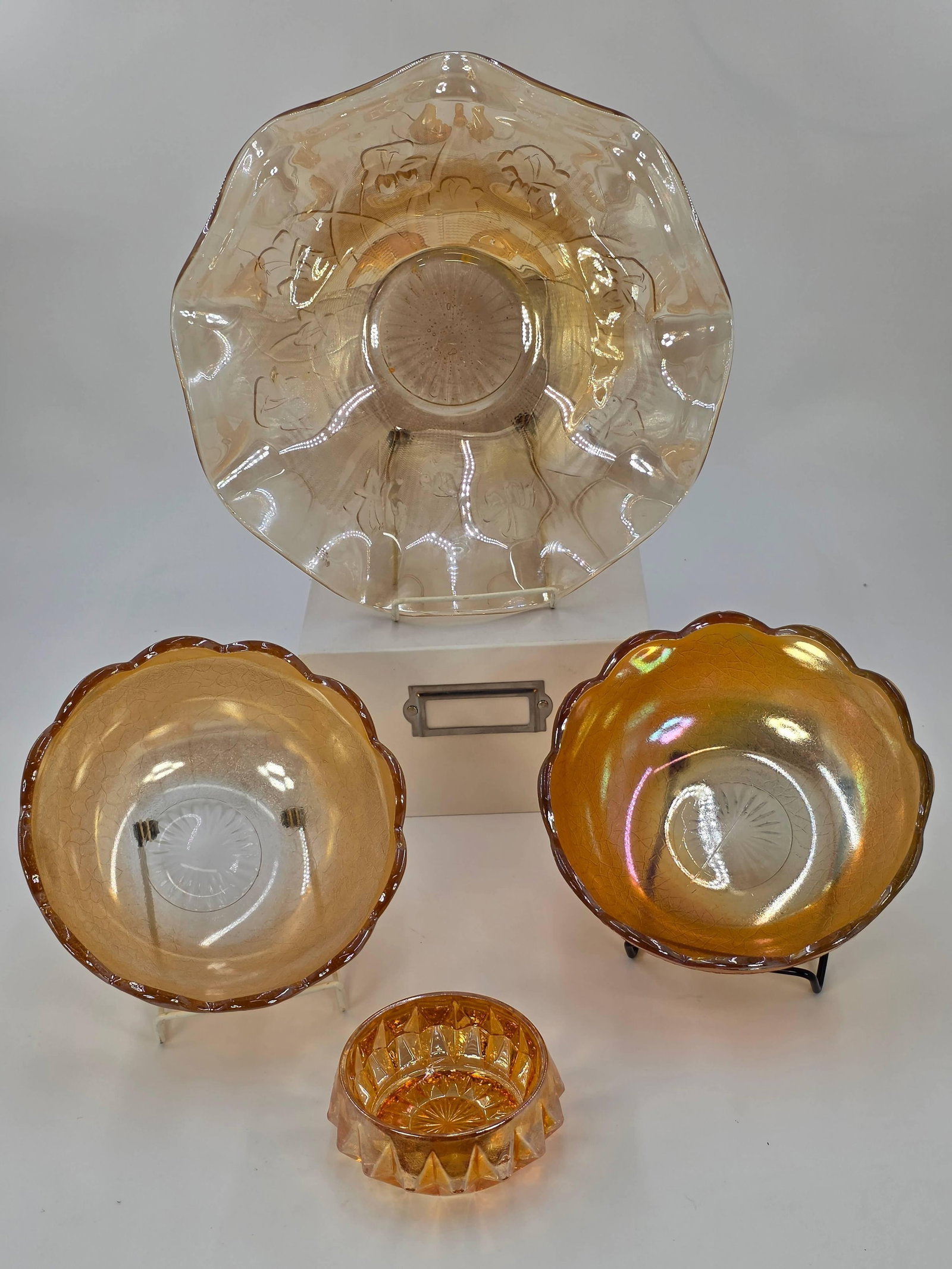 4 Jeanette Carnival Glass Items, Vintage, INV. 1039: Approx. 11 1/2" dia. Iris and Herring Bone bowl. Approx. 7 3/8" dia Marigold Crackle bowls. Approx. 1 5/8" height of ashtray.
