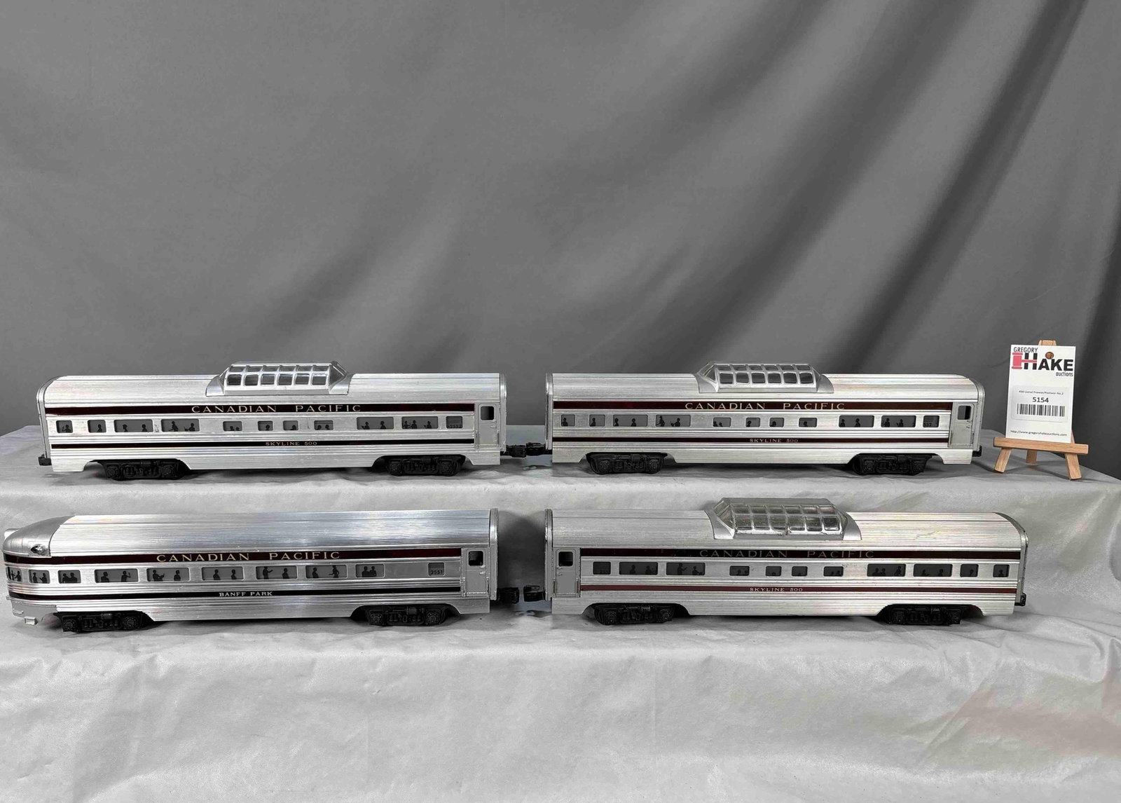 4 Lionel Postwar Canadian Pacific Passenger Cars: 4 Lionel Postwar Canadian Pacific Passenger Cars. (3) 2552 Vista Domes, and a 2551 Observation, C7. Some of the stripes are aftermarket. Size 17x13x4