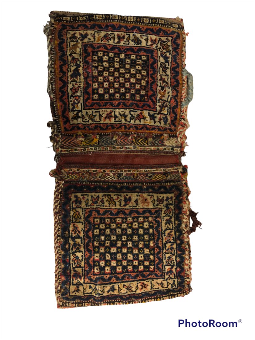 Persian Antique Saddle Bag: Persian Saddle bag 19th/early 20th century. Hand knotted. Has tag made in Iran. Dim ensions: 28 inches when fully open x 13 inches x .5 inches thick Condition: Fine. Please feel free to ask for a cond