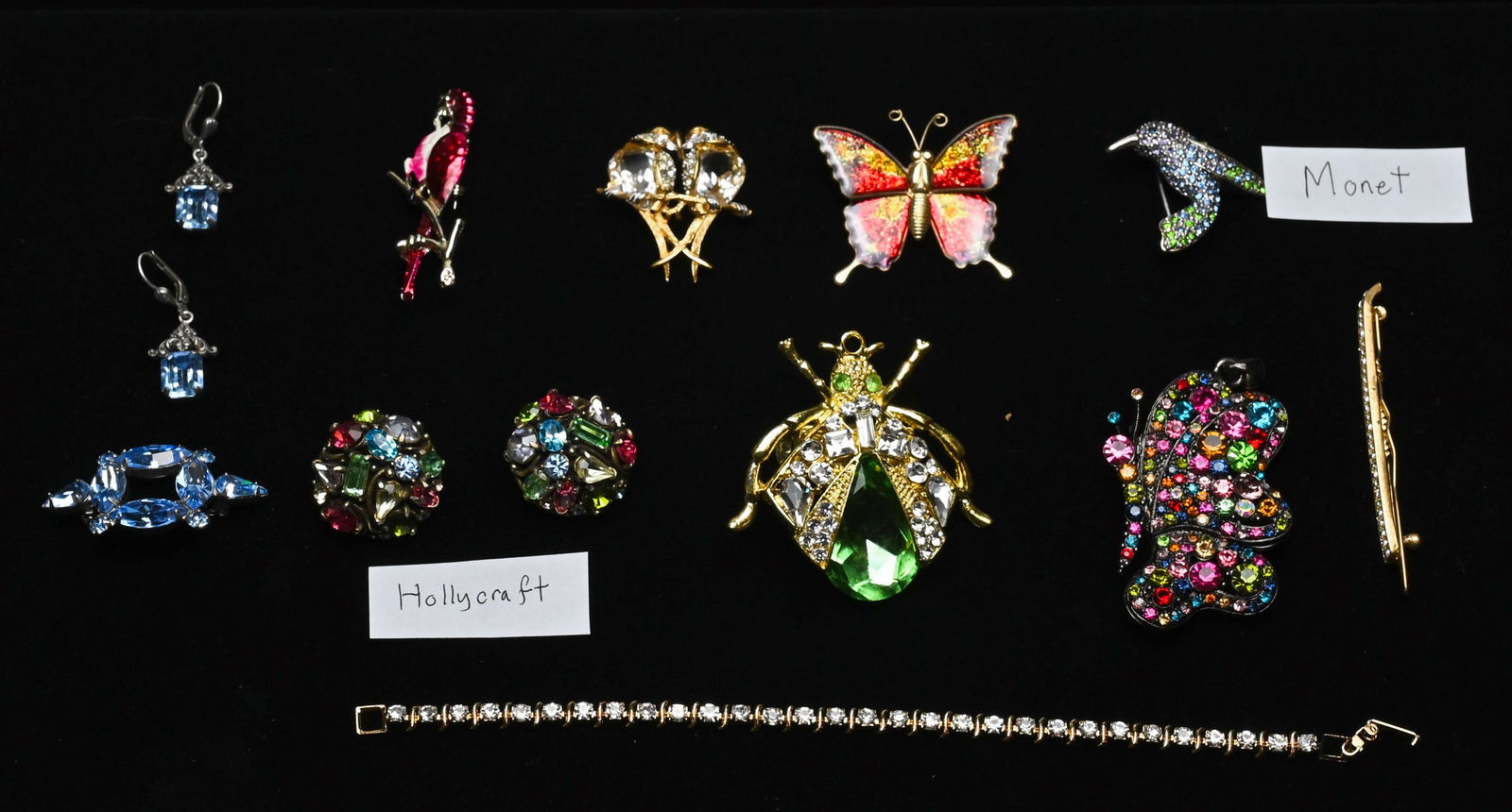 Lot of 13 Vintage Jewelry Pieces Including Hollycraft and Monet: This lot features 13 pieces of vintage jewelry from Hollycraft and Monet, showcasing their iconic sparkle and craftsmanship. Includes a mix of brooches with pastel rhinestones, gold-tone chain necklac