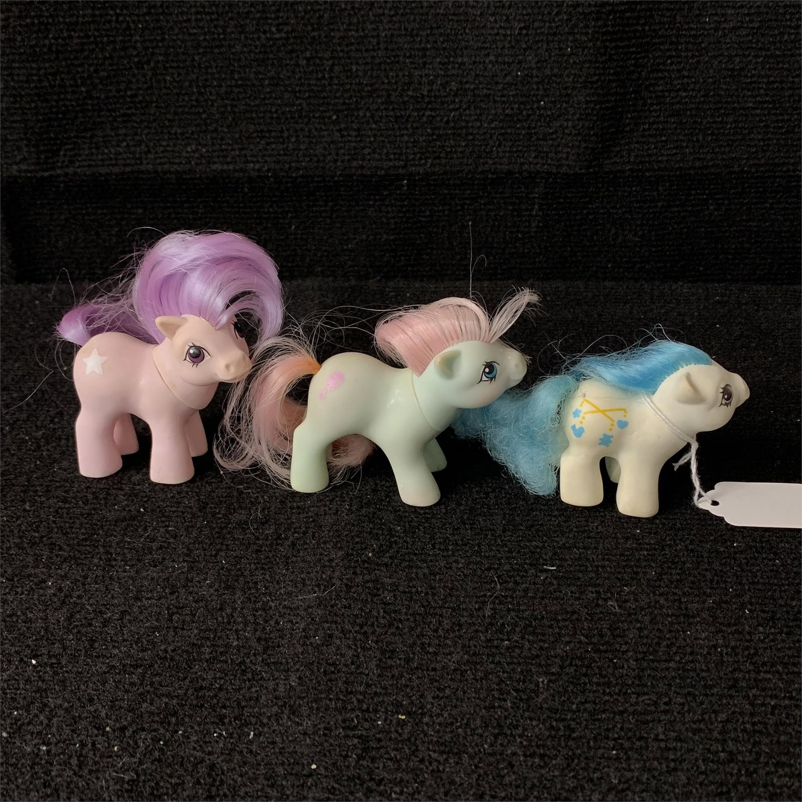 My Little Pony G1 Baby Ember, Dangles & Baby Cuddles: G1 MLP Year 7 (88-89) Newborn Baby Pony Dangles, Year 3 (84-85) Baby Ember and 1984 Baby Buggy Baby Cuddles. Dangles has a pen mark near her tail and a couple of dings in her body but none of the thre
