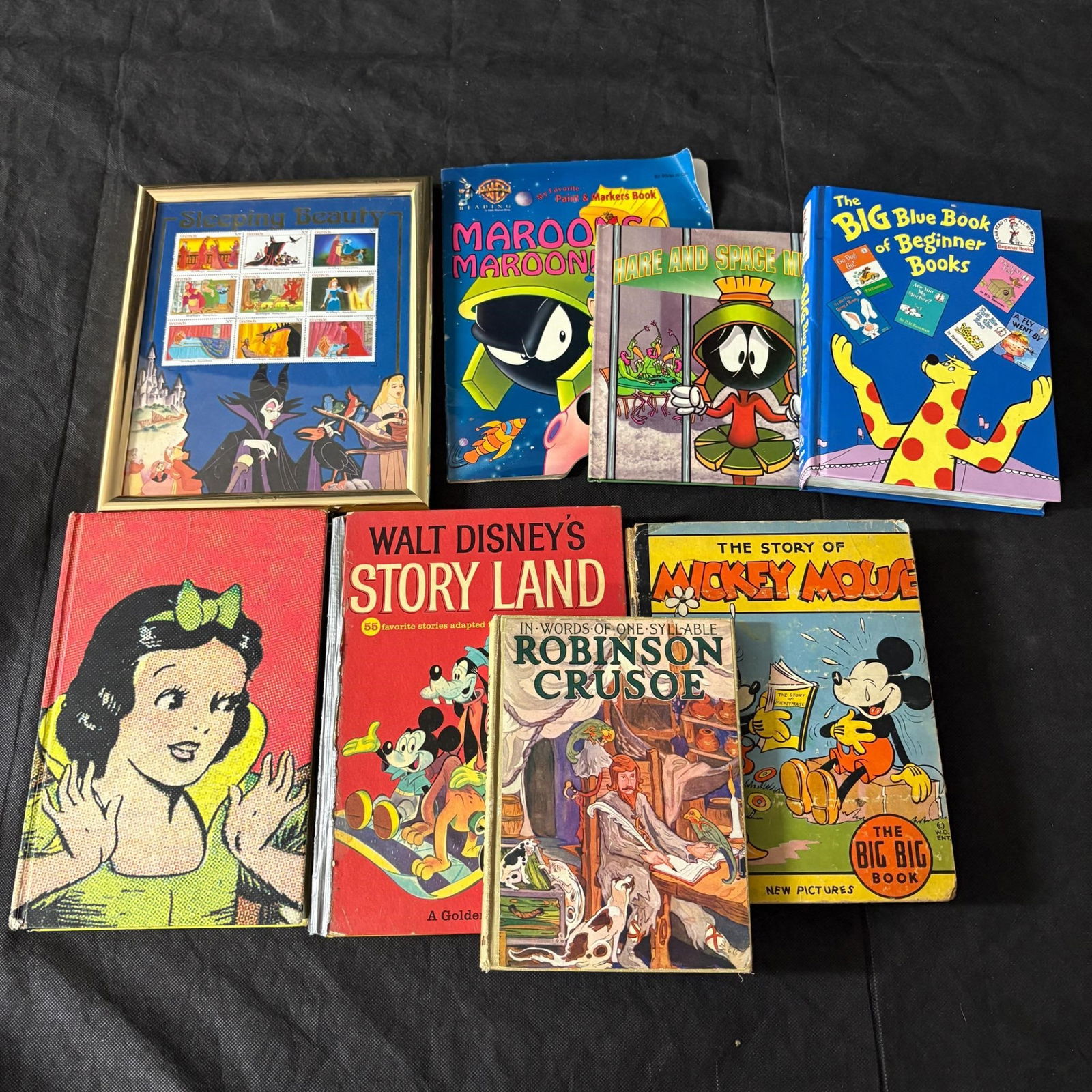 1985 Robinson Crusoe, and other Vintage Books: Lot of Vintage Books, Modern Looney Tunes Books, and Sleeping Beauty Stamp Collection. Includes 1985 Copy of Robinson Crusoe with inscription that it was awarded to a student for regular attendance du
