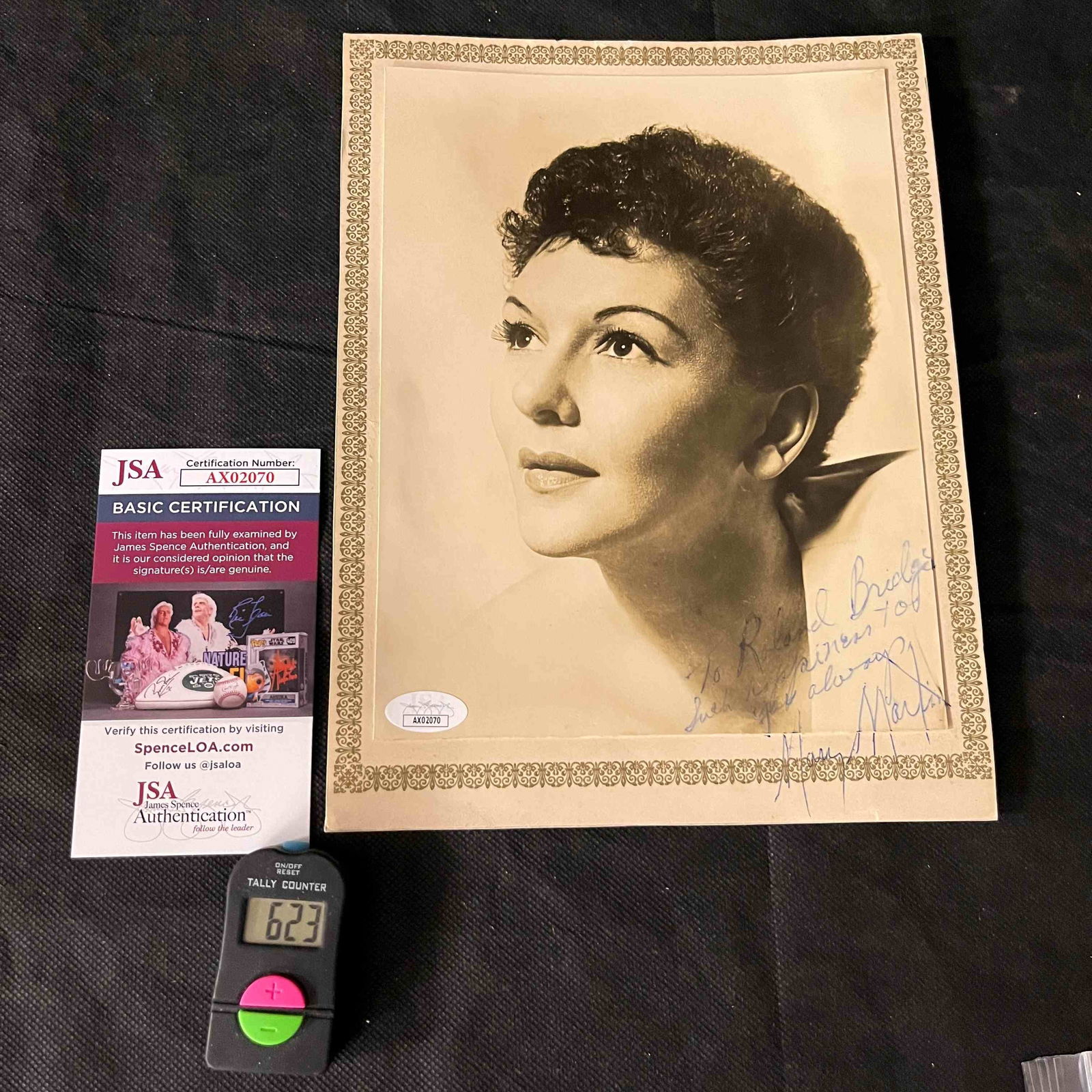 Mary Martin Autographed Photograph with JSA Authentication: An autographed black and white photographic portrait of Mary Martin, rendered in a mid-20th-century style. The photograph features a printed or embossed ornate gold-toned scrollwork border. It bears a