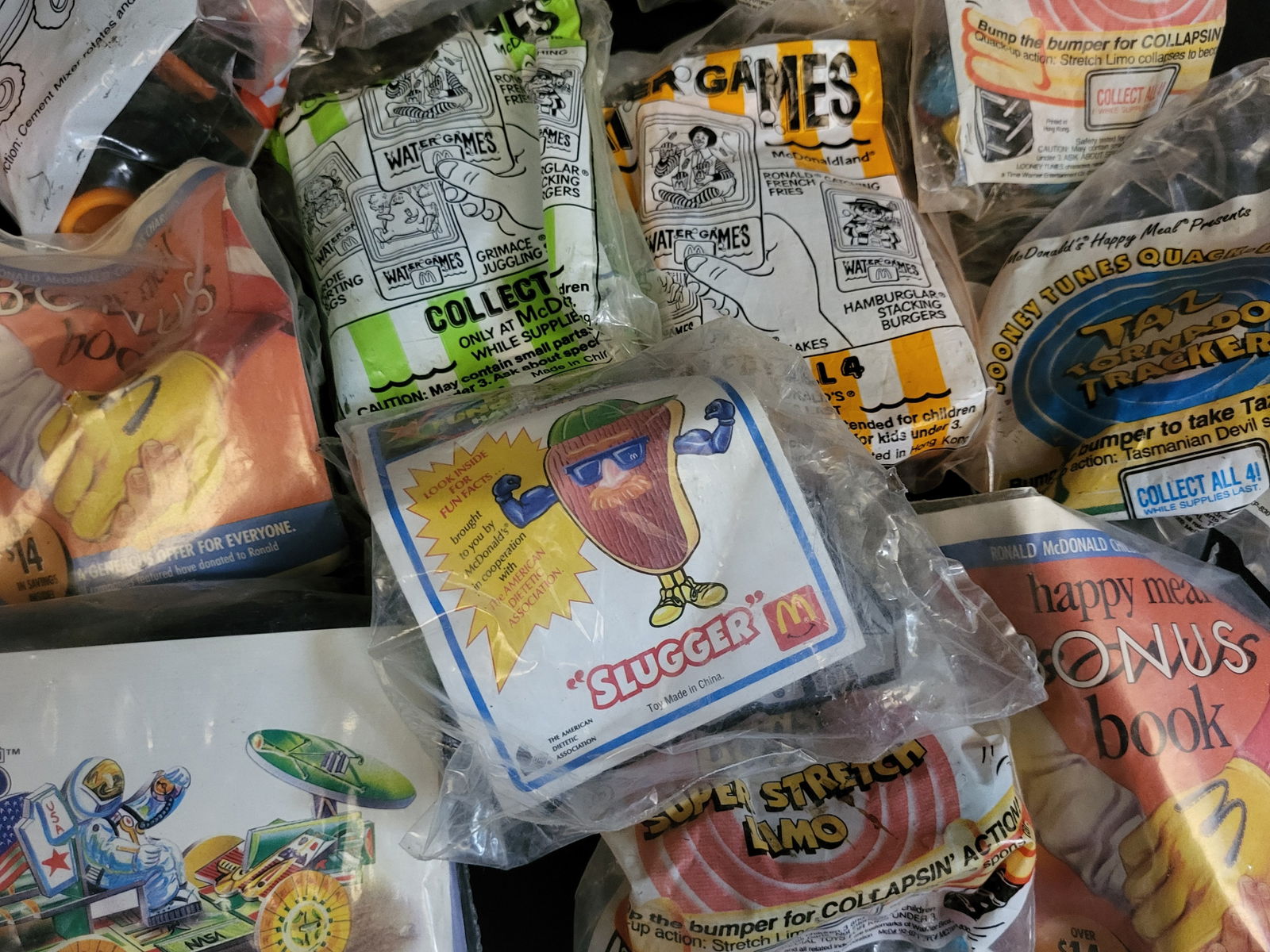 I00429 A Collection of Vintage Sealed McDonald's Happy Meal Toys: BID PER WHAT YOU SEE IN THE PHOTO, NOT THE AI GENERATED TITLES AND DESCRIPTIONS! A collection of vintage McDonald's Happy Meal toys and promotional items, primarily dating from the early 1990s. The gr