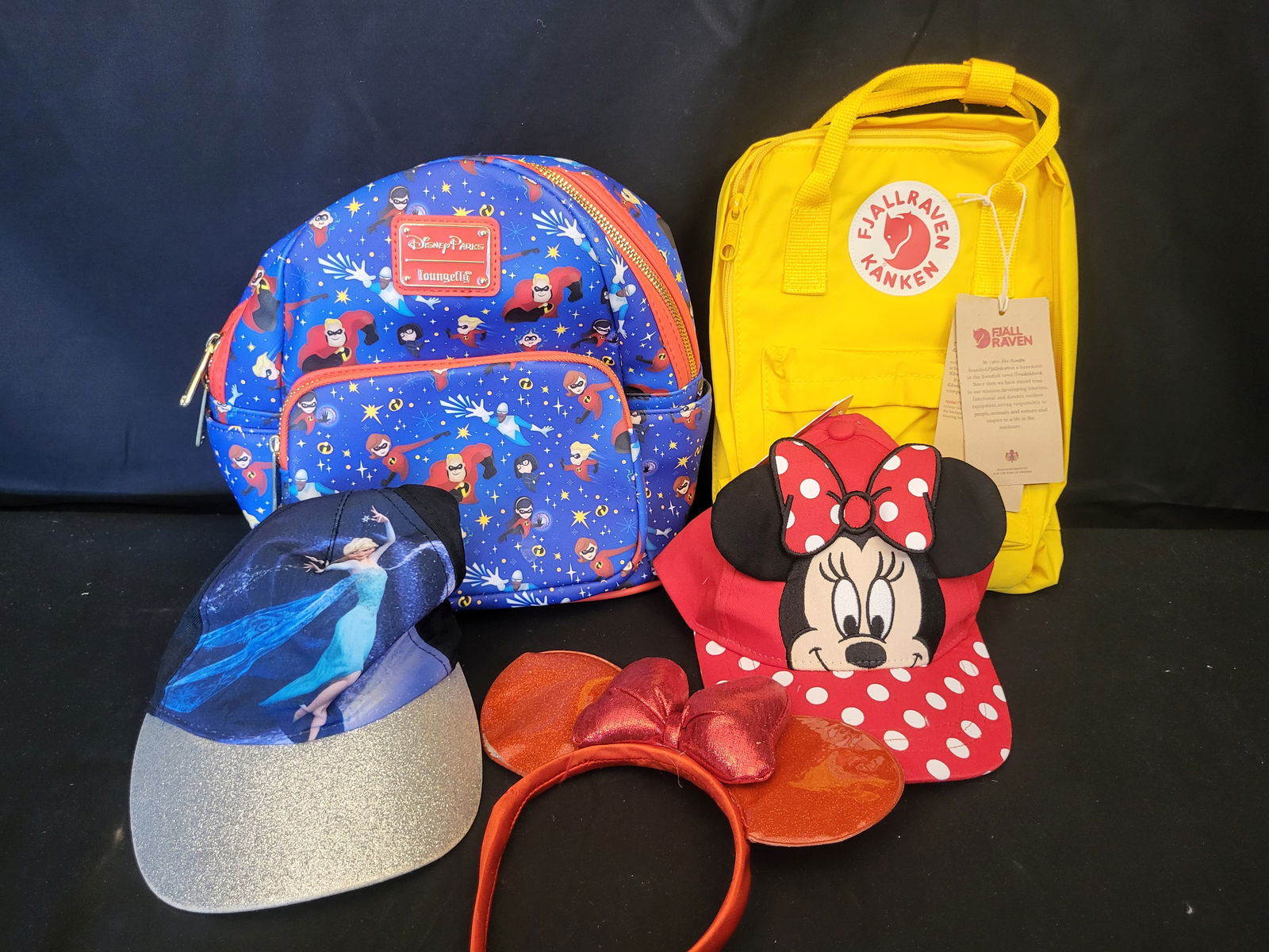 I00544 A Collection of Disney Parks Loungefly The Incredibles and Fj?¤llr?¤ven Accessories: BID PER WHAT YOU SEE IN THE PHOTO, NOT THE AI GENERATED TITLES AND DESCRIPTIONS! This collection features a Disney Parks Loungefly The Incredibles AOP Mini Backpack, constructed from blue synthetic le