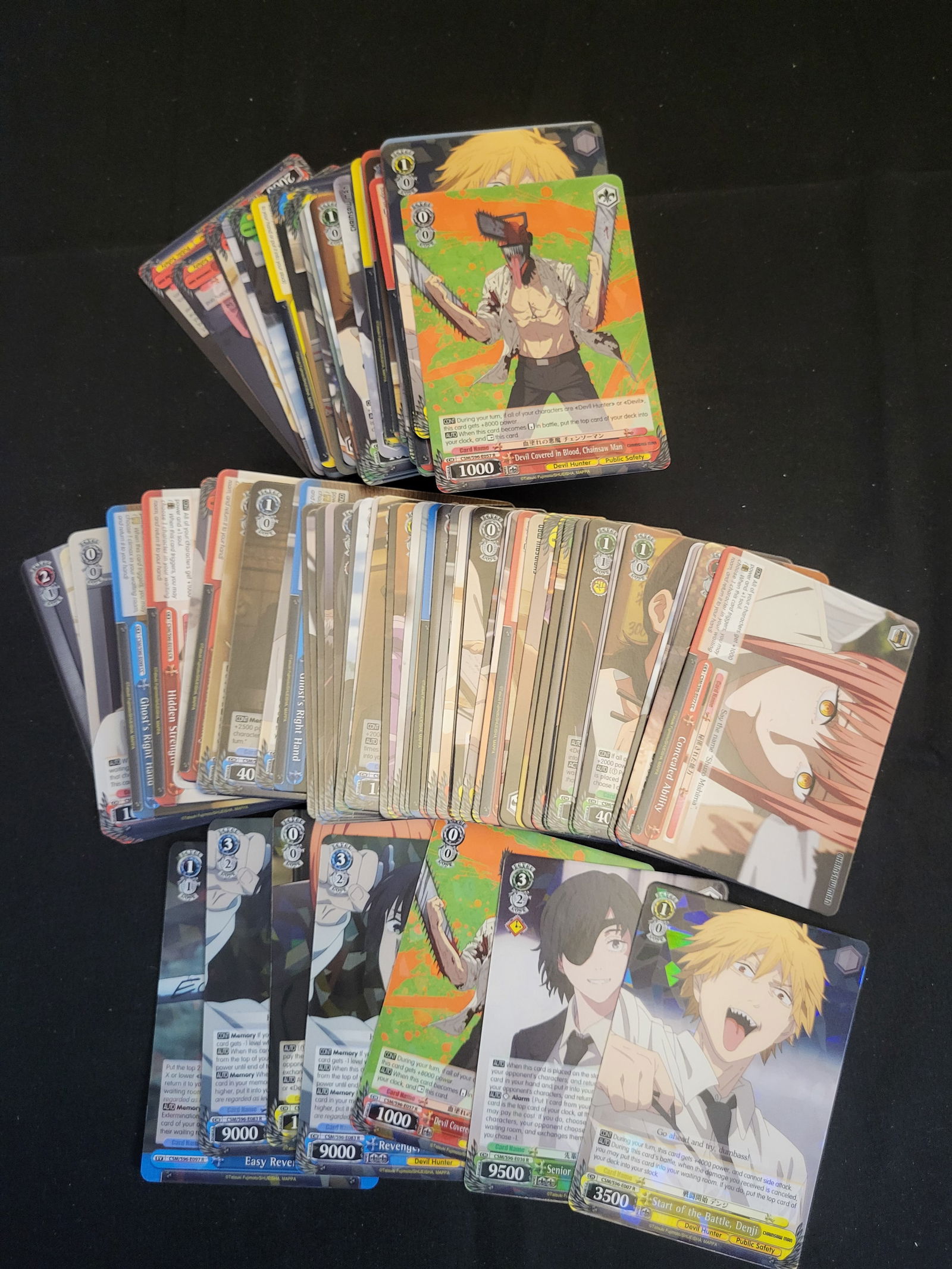 I00222 A Collection of Weiss Schwarz Chainsaw Man Trading Cards: BID PER WHAT YOU SEE IN THE PHOTO, NOT THE AI GENERATED TITLES AND DESCRIPTIONS! A collection of Weiss Schwarz trading cards featuring characters and scenes from the Chainsaw Man anime and manga serie