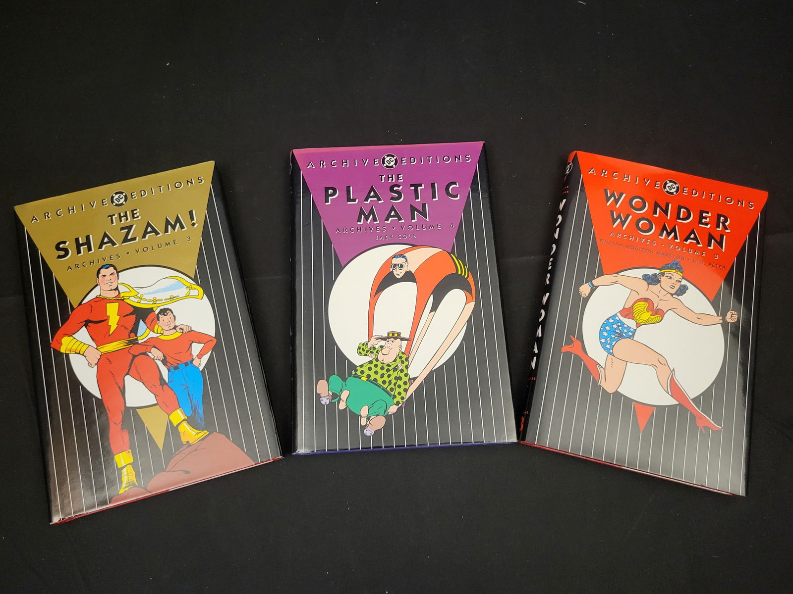 A Trio of DC Archive Editions Hardcover Graphic Novels: BID PER WHAT YOU SEE IN THE PHOTO, NOT THE AI GENERATED TITLES AND DESCRIPTIONS! A trio of DC Archive Editions hardcover books re-presenting stories from the Golden Age of Comics. The collection inclu