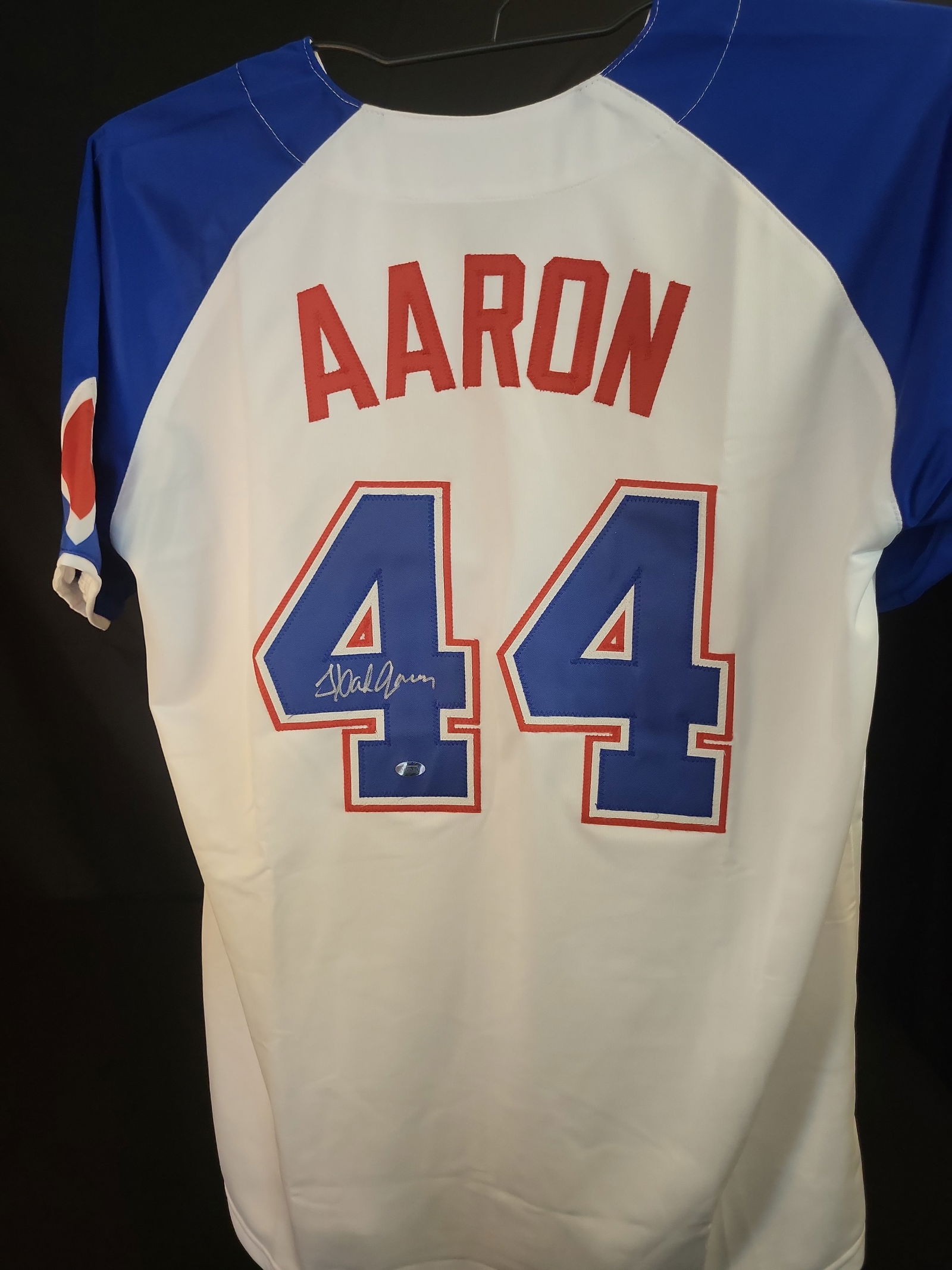 I01015 | Hank Aaron Autographed Atlanta Braves Commemorative Jersey, Mounted Memories Authenticated: BID PER WHAT YOU SEE IN THE PHOTO, NOT THE AI GENERATED TITLES AND DESCRIPTIONS! Hank Aaron Autographed Atlanta Braves Commemorative Jersey, Mounted Memories Authenticated This professional commemorat