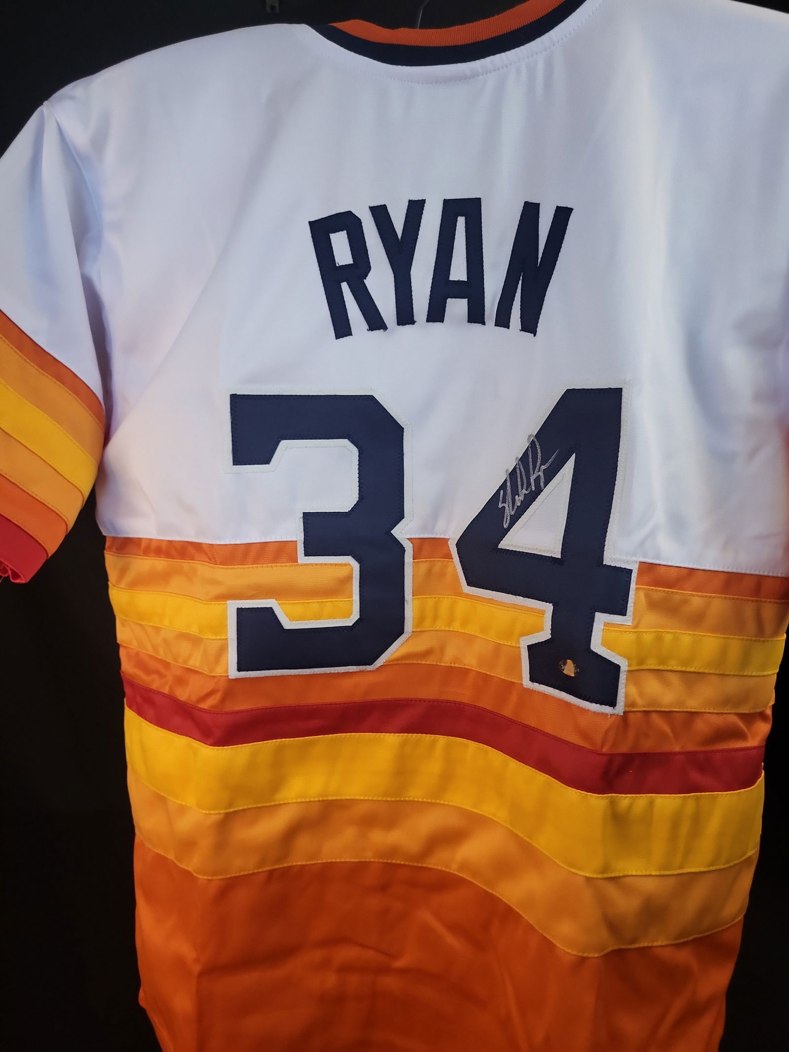 I01020 | Nolan Ryan Autographed Houston Astros Tequila Sunrise Jersey, Nolan Ryan Authenticated: BID PER WHAT YOU SEE IN THE PHOTO, NOT THE AI GENERATED TITLES AND DESCRIPTIONS! Nolan Ryan Autographed Houston Astros Tequila Sunrise Jersey, Nolan Ryan Authenticated This lot features a modern repro