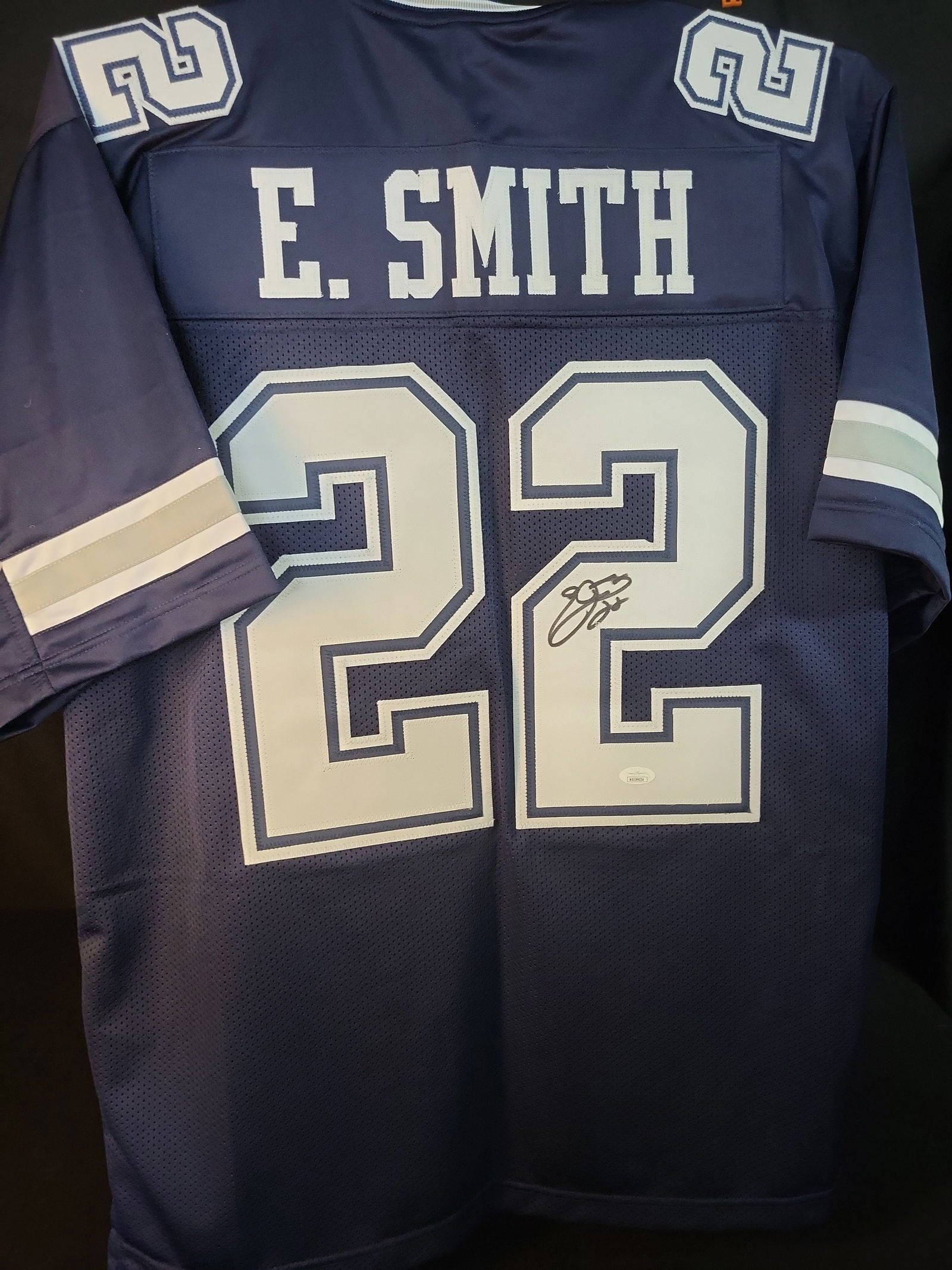 I00984 | Emmitt Smith Signed Dallas Cowboys Style Custom Football Jersey, JSA Authenticated: BID PER WHAT YOU SEE IN THE PHOTO, NOT THE AI GENERATED TITLES AND DESCRIPTIONS! Emmitt Smith Signed Dallas Cowboys Style Custom Football Jersey, JSA Authenticated This lot features a custom navy blue