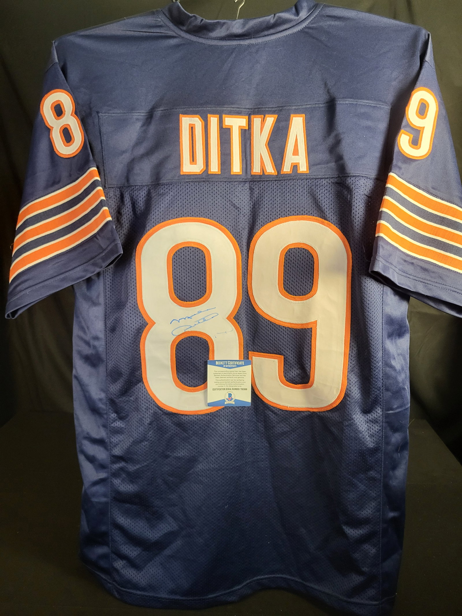 I00574 | Mike Ditka Autographed Chicago Bears Custom Jersey Beckett: BID PER WHAT YOU SEE IN THE PHOTO, NOT THE AI GENERATED TITLES AND DESCRIPTIONS! Mike Ditka Autographed Chicago Bears Custom Jersey Beckett This navy blue Chicago Bears jersey features the name DITKA 