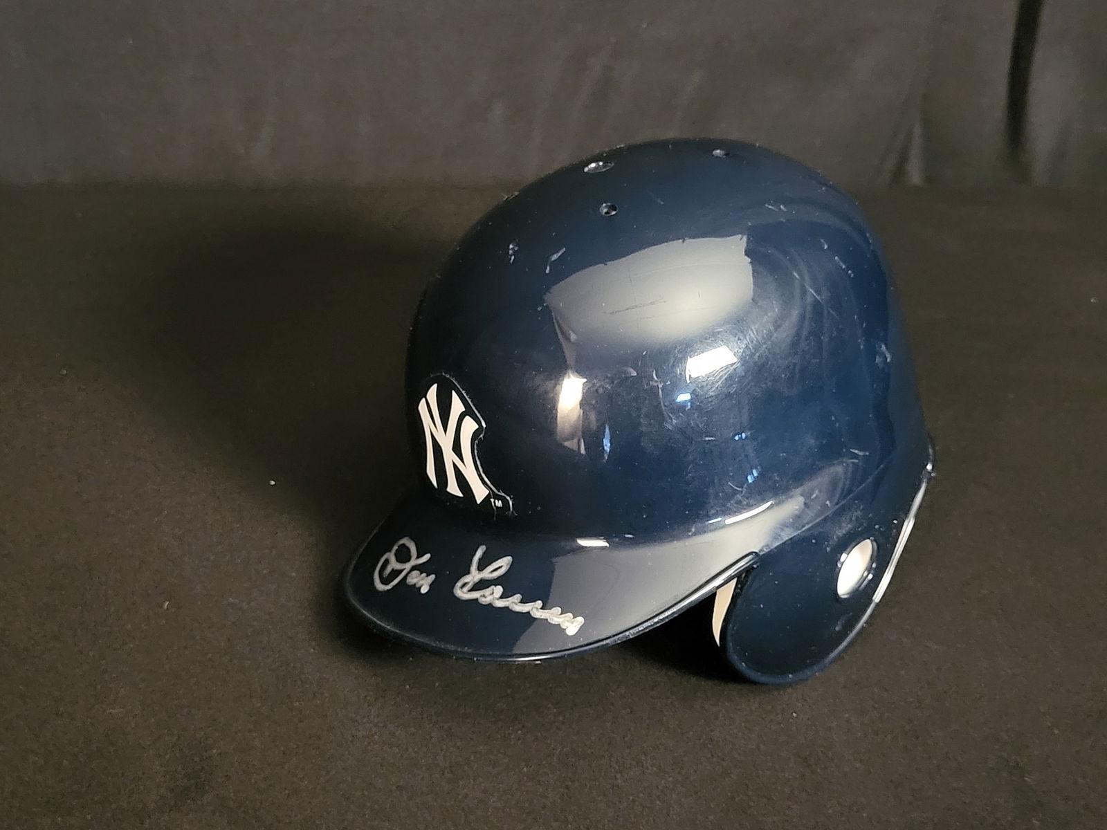 I00570 | New York Yankees Autographed Souvenir Mini Batting Helmet Signed by Don Larsen, JSA Authent: BID PER WHAT YOU SEE IN THE PHOTO, NOT THE AI GENERATED TITLES AND DESCRIPTIONS! New York Yankees Autographed Souvenir Mini Batting Helmet Signed by Don Larsen, JSA Authenticated A navy blue New York