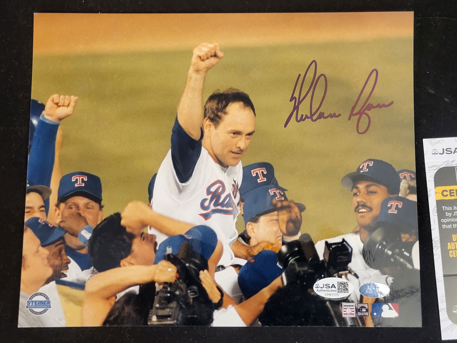 I00704 | Nolan Ryan Autographed Texas Rangers Color Photograph with JSA and Steiner Authentication: BID PER WHAT YOU SEE IN THE PHOTO, NOT THE AI GENERATED TITLES AND DESCRIPTIONS! Nolan Ryan Autographed Texas Rangers Color Photograph with JSA and Steiner Authentication This color photograph depicts