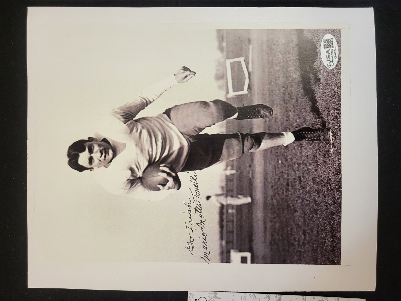 I00725 | Mario Motts Tonelli Autographed Black and White Photo JSA: BID PER WHAT YOU SEE IN THE PHOTO, NOT THE AI GENERATED TITLES AND DESCRIPTIONS! Mario Motts Tonelli Autographed Black and White Photo JSA A black and white photograph signed by former American footba