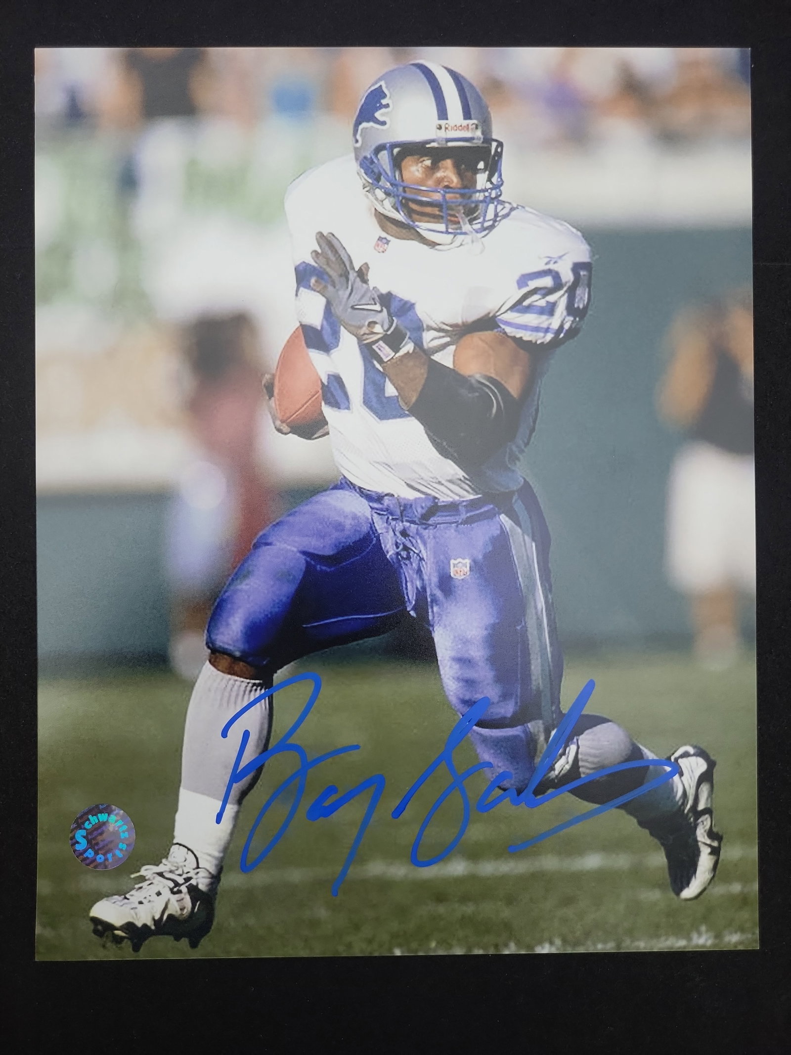 I01697 | Barry Sanders Autographed Detroit Lions Action Photograph with Schwartz Sports: BID PER WHAT YOU SEE IN THE PHOTO, NOT THE AI GENERATED TITLES AND DESCRIPTIONS! Barry Sanders Autographed Detroit Lions Action Photograph with Schwartz Sports Authentication This is an autographed co