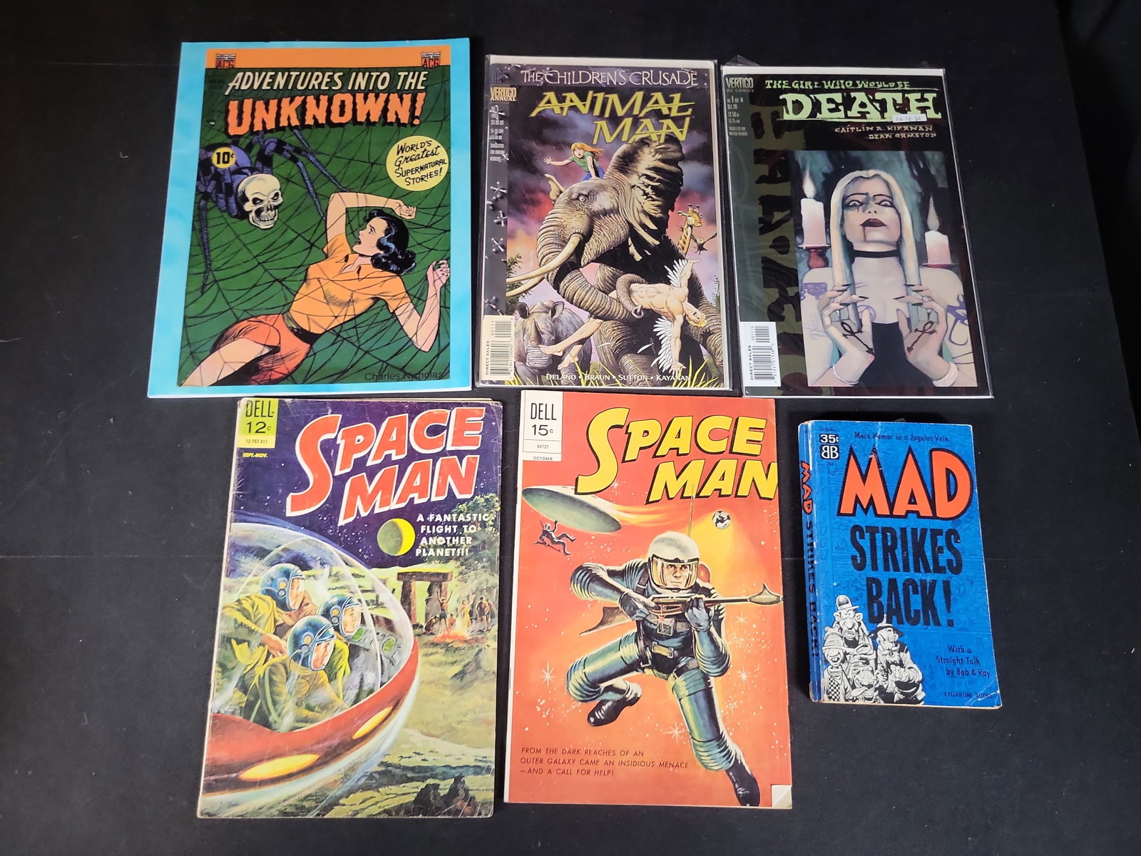 I02950 | A Collection of Vintage and Modern Comic Books and Humor Paperback: BID PER WHAT YOU SEE IN THE PHOTO, NOT THE AI GENERATED TITLES AND DESCRIPTIONS! A Collection of Vintage and Modern Comic Books and Humor Paperback This collection consists of six items, including vin