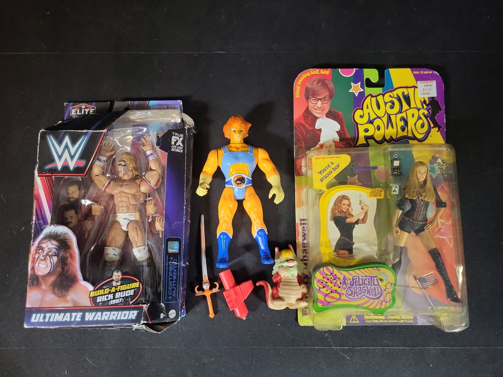 I02902 | Three Action Figures Including Mattel WWE Ultimate Warrior, LJN Thundercats Lion-O, and: BID PER WHAT YOU SEE IN THE PHOTO, NOT THE AI GENERATED TITLES AND DESCRIPTIONS! Three Action Figures Including Mattel WWE Ultimate Warrior, LJN Thundercats Lion-O, and McFarlane Toys Austin Powers Fe