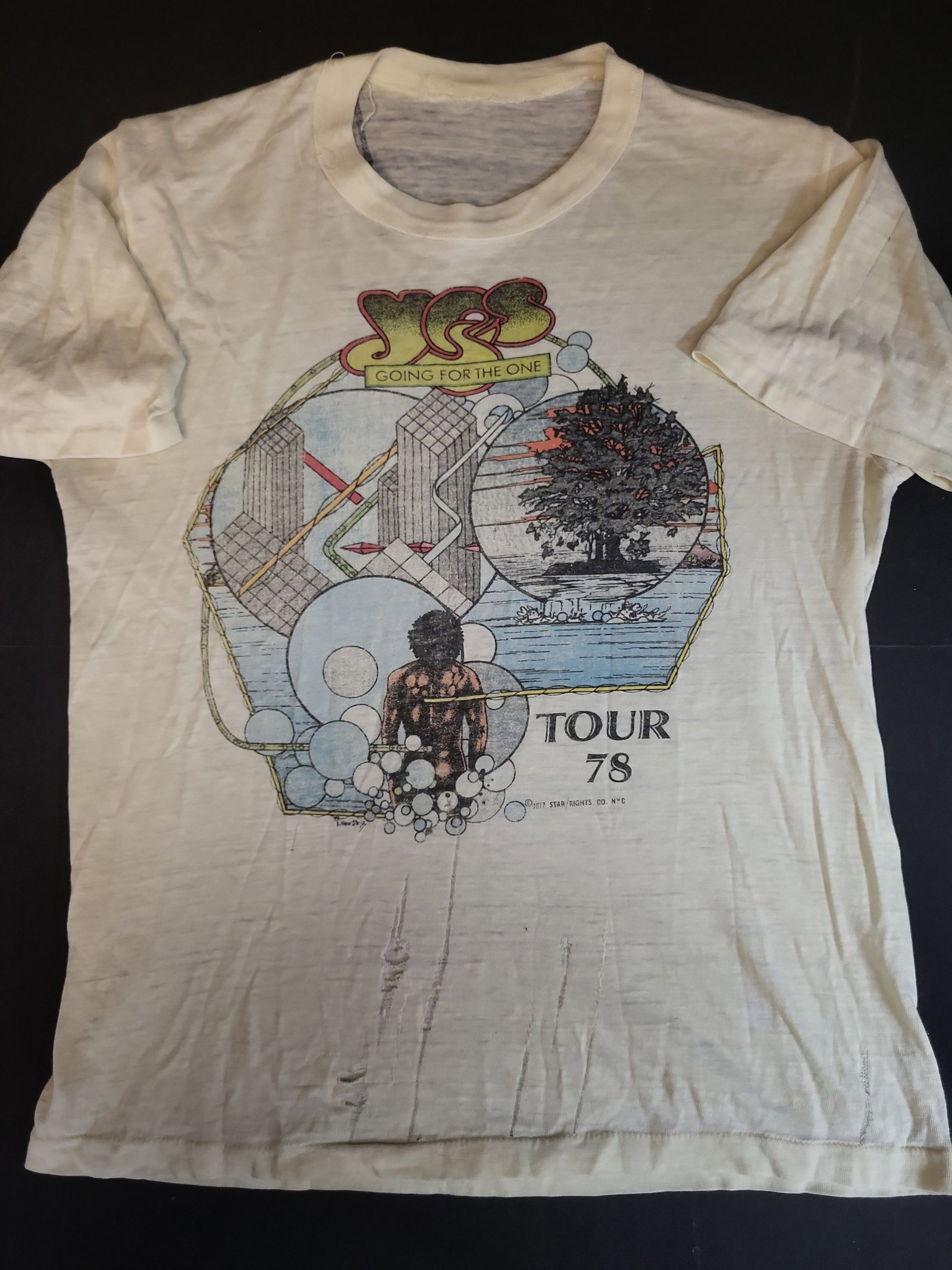 I02750 | Vintage Yes 1978 Going for the One Tour T-Shirt: BID PER WHAT YOU SEE IN THE PHOTO, NOT THE AI GENERATED TITLES AND DESCRIPTIONS! Vintage Yes 1978 Going for the One Tour T-Shirt This vintage short-sleeved t-shirt commemorates the English progressive
