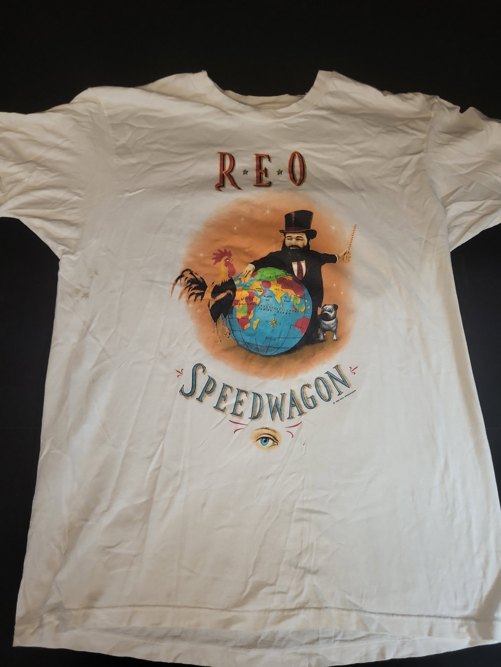 I02752 | Vintage REO Speedwagon The Earth, A Small Man, His Dog and a Chicken Concert T-Shirt, 1990: BID PER WHAT YOU SEE IN THE PHOTO, NOT THE AI GENERATED TITLES AND DESCRIPTIONS! Vintage REO Speedwagon The Earth, A Small Man, His Dog and a Chicken Concert T-Shirt, 1990 This vintage short-sleeved, 