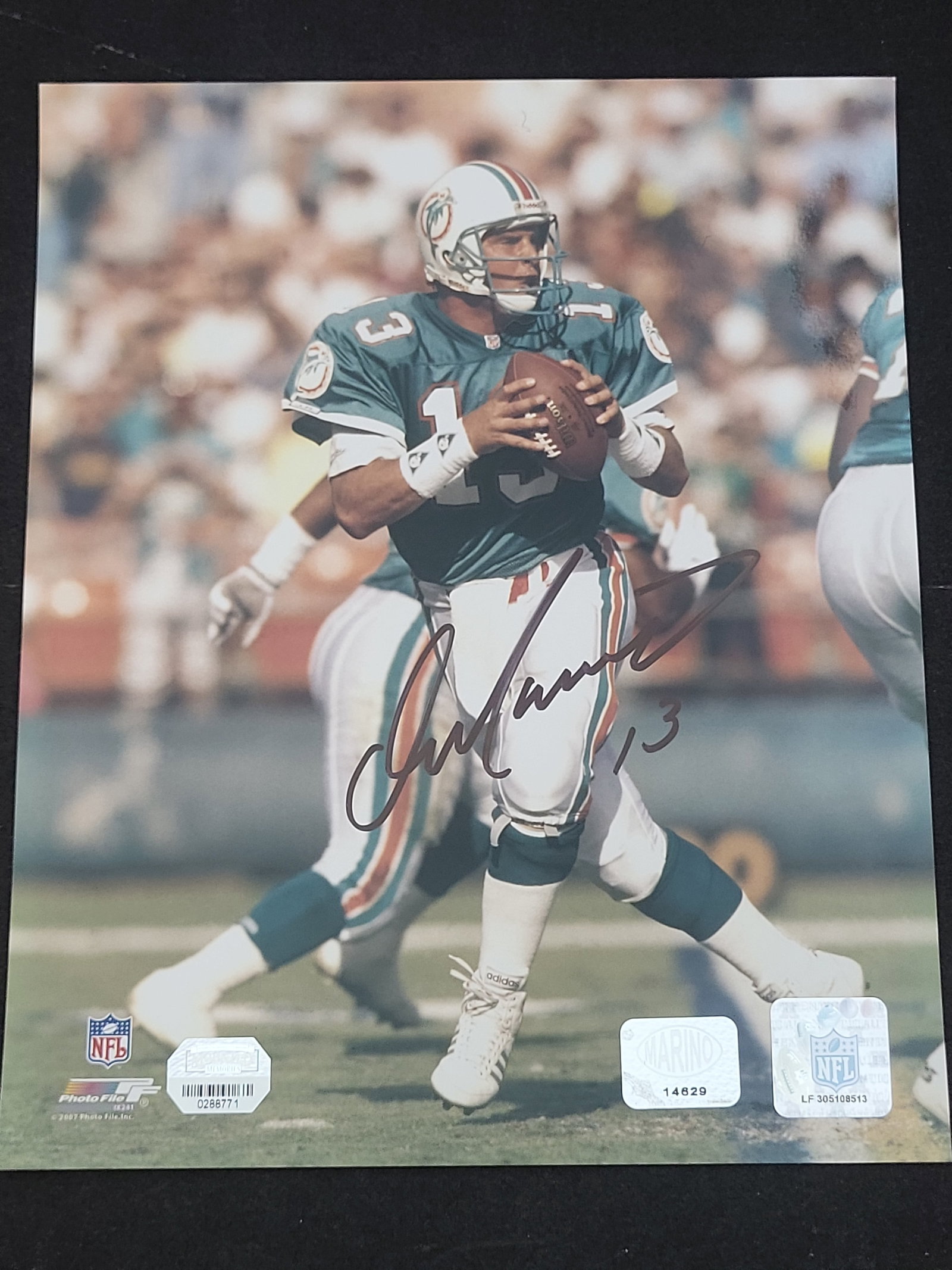 I03867 | Dan Marino Autographed 8x10 Miami Dolphins Color Photograph with Authentication: BID PER WHAT YOU SEE IN THE PHOTO, NOT THE AI GENERATED TITLES AND DESCRIPTIONS! This is an 8x10 inch color glossy photograph signed by Hall of Fame quarterback Dan Marino of the Miami Dolphins. The a