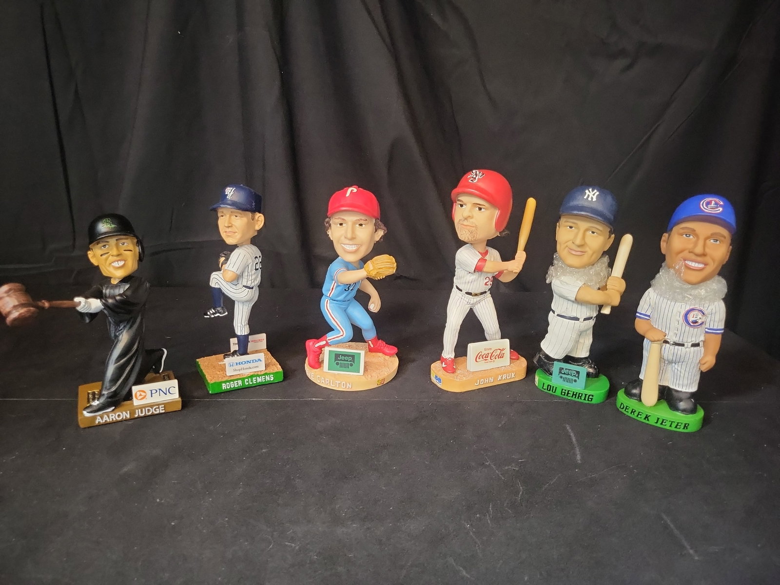I03059 | A Collection of Six Major League Baseball Player Bobbleheads Including Aaron Judge and Lou: BID PER WHAT YOU SEE IN THE PHOTO, NOT THE AI GENERATED TITLES AND DESCRIPTIONS! A Collection of Six Major League Baseball Player Bobbleheads Including Aaron Judge and Lou Gehrig This collection consi