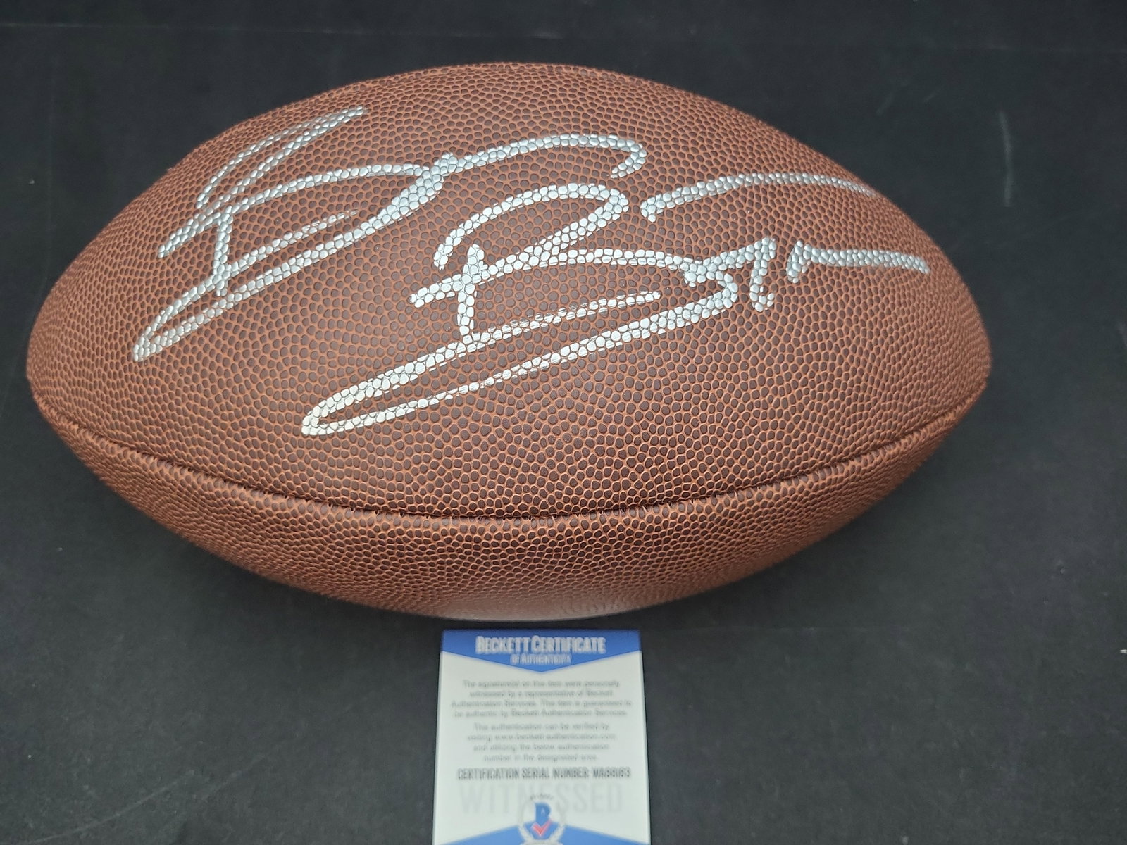 I03571 | Brian Bosworth Signed Wilson Super Grip Official Size NFL Football Beckett Witnessed: BID PER WHAT YOU SEE IN THE PHOTO, NOT THE AI GENERATED TITLES AND DESCRIPTIONS! Brian Bosworth Signed Wilson Super Grip Official Size NFL Football Beckett Witnessed Authentication This signed Wilson 