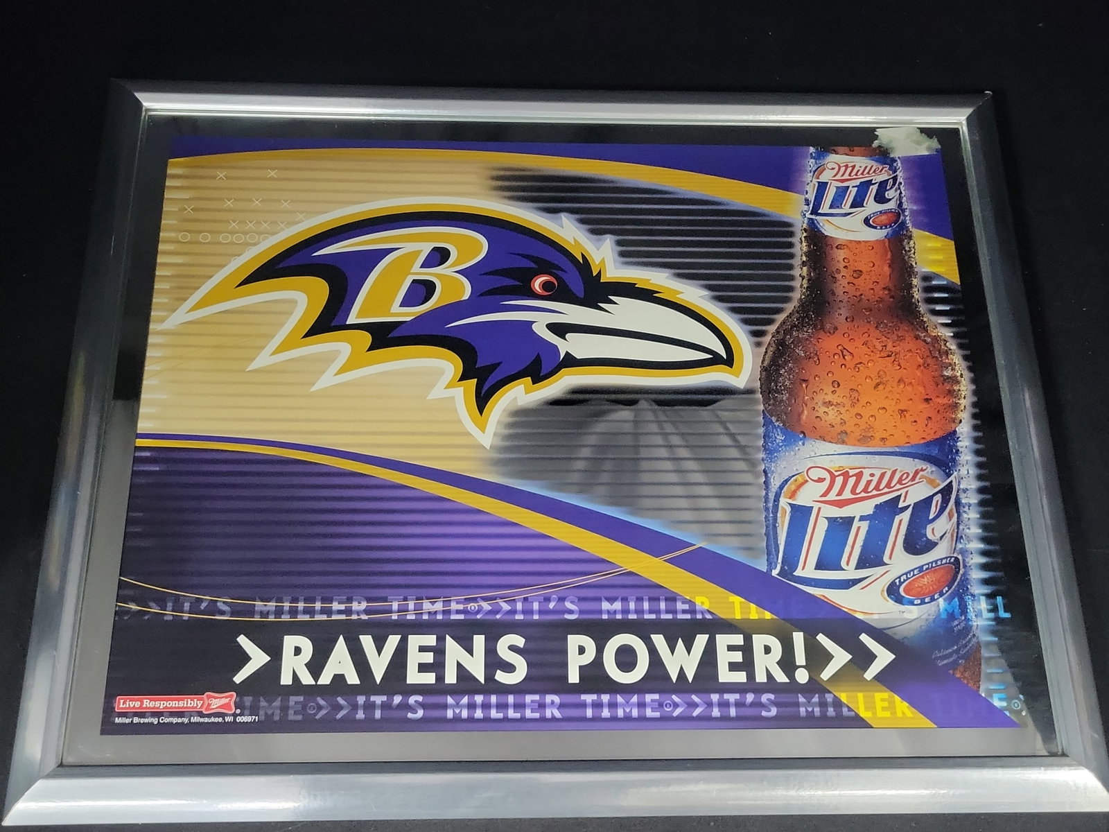 I03178 | Baltimore Ravens Miller Lite Promotional Mirror in Metallic Frame: BID PER WHAT YOU SEE IN THE PHOTO, NOT THE AI GENERATED TITLES AND DESCRIPTIONS! A promotional brewery mirror featuring the Baltimore Ravens NFL team and Miller Lite beer. The graphic design incorpora