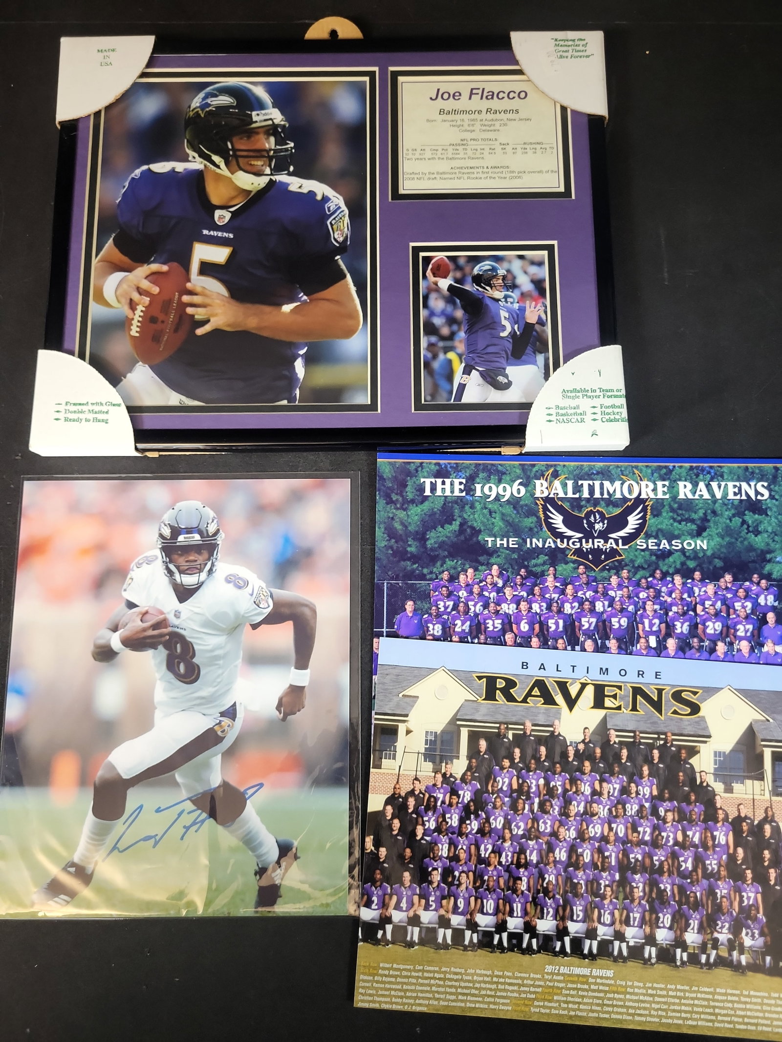 I03645 | A Collection of Baltimore Ravens Memorabilia Including Framed Joe Flacco Plaque and: BID PER WHAT YOU SEE IN THE PHOTO, NOT THE AI GENERATED TITLES AND DESCRIPTIONS! A Collection of Baltimore Ravens Memorabilia Including Framed Joe Flacco Plaque and Autographed Lamar Jackson Photo Thi
