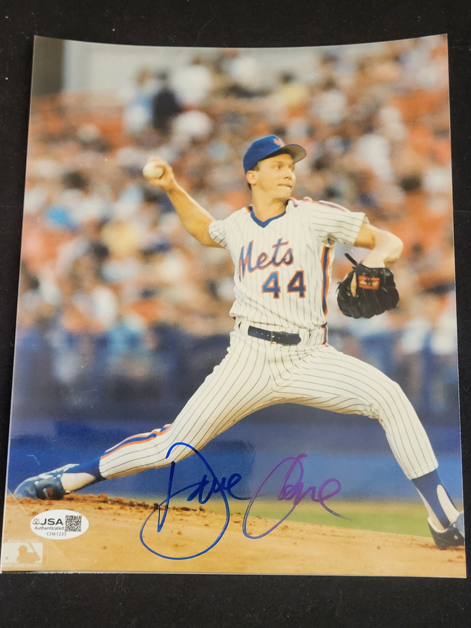 I00737 | David Cone Autographed New York Mets Pitching Photograph: BID PER WHAT YOU SEE IN THE PHOTO, NOT THE AI GENERATED TITLES AND DESCRIPTIONS! David Cone Autographed New York Mets Pitching Photograph This autographed color photograph depicts New York Mets pitche