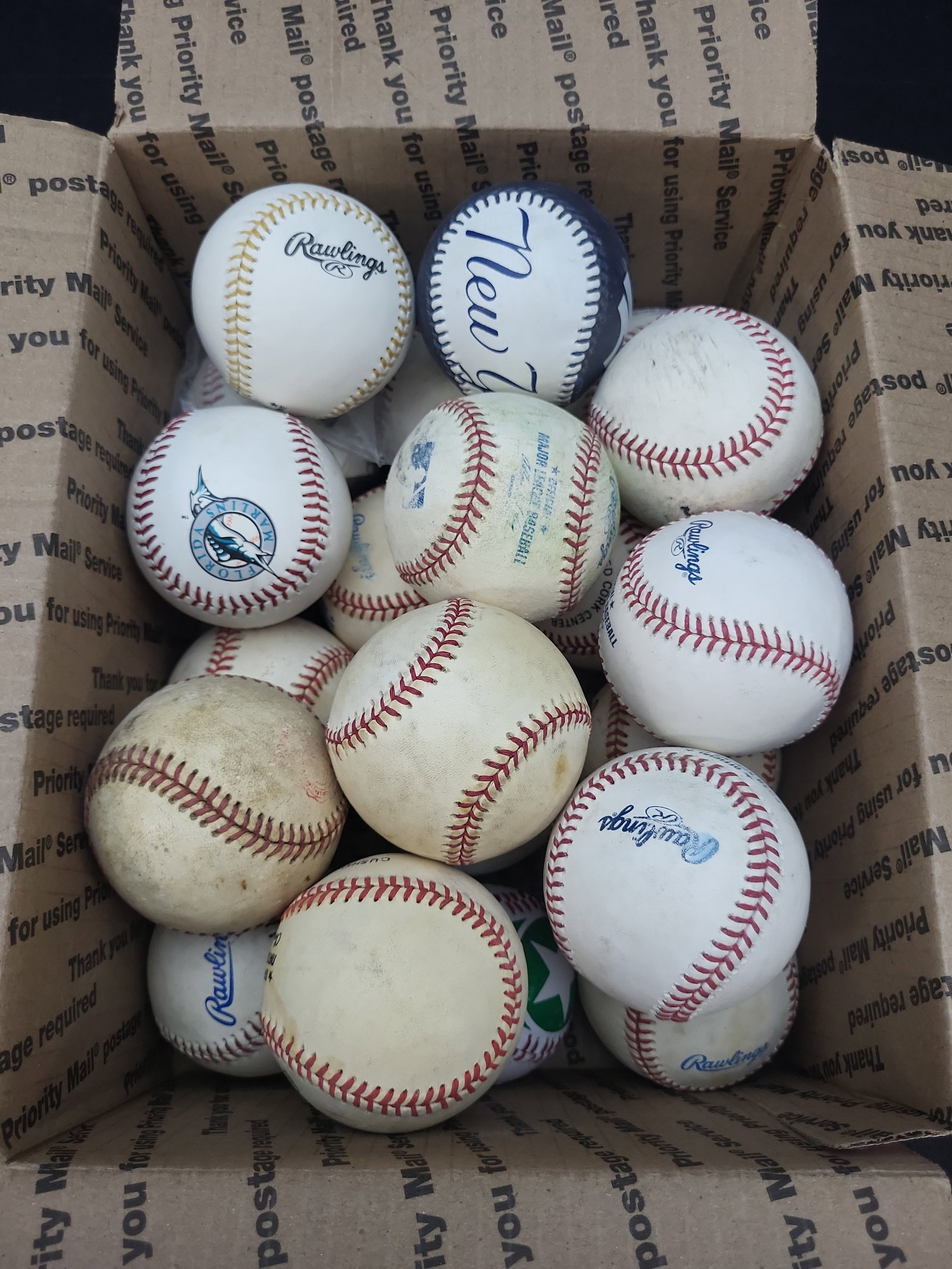 I03328 | A Collection of Approximately 17 Baseballs, Including Rawlings and Souvenir Examples: BID PER WHAT YOU SEE IN THE PHOTO, NOT THE AI GENERATED TITLES AND DESCRIPTIONS! This lot consists of a collection of approximately 17 baseballs, featuring a diverse mix of official league, souvenir, 