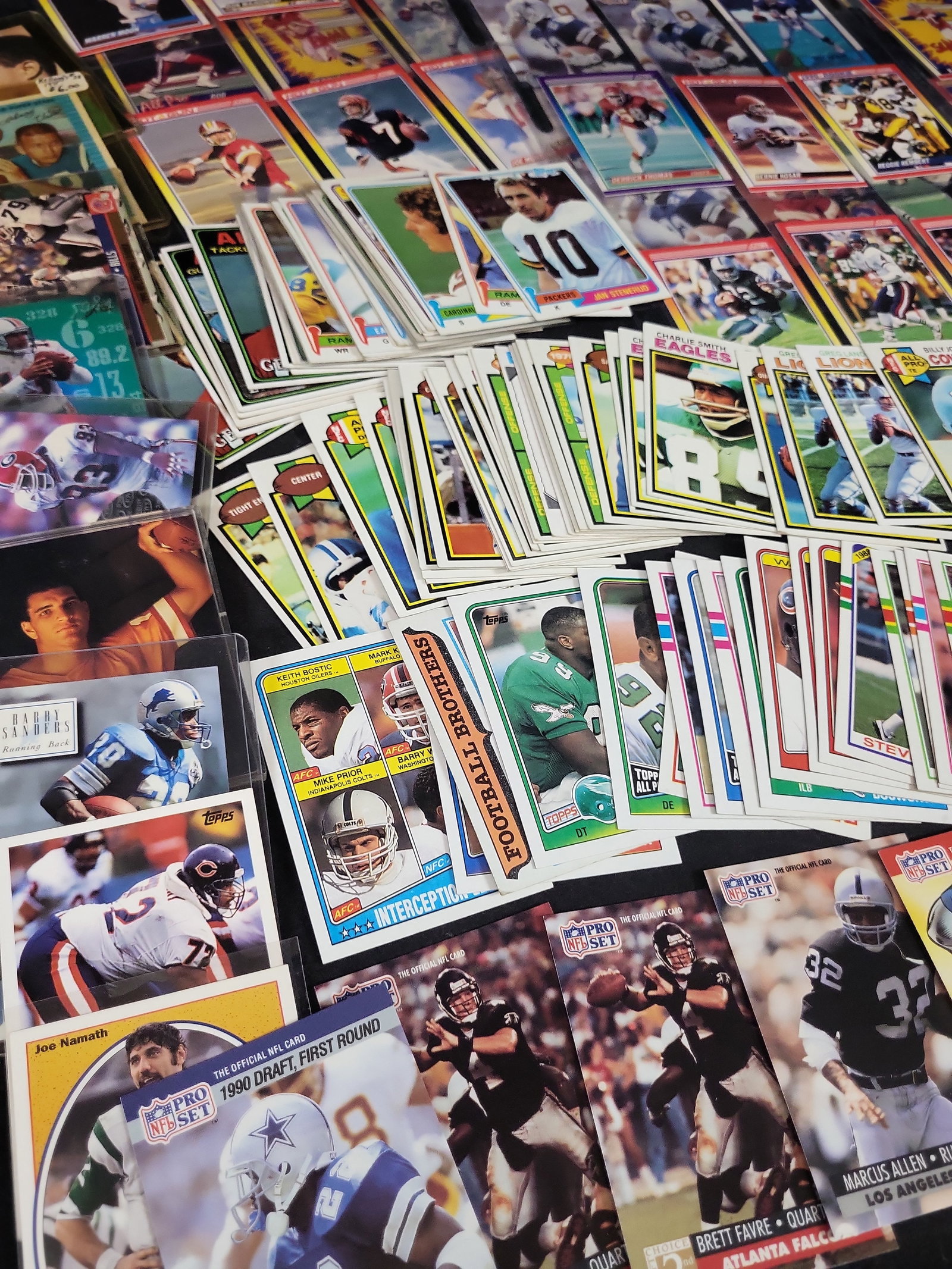 I03871 | A Collection of NFL Trading Cards from the 1970s to 1990s Featuring Rookie Cards and Hall: BID PER WHAT YOU SEE IN THE PHOTO, NOT THE AI GENERATED TITLES AND DESCRIPTIONS! This lot contains an extensive assortment of American football trading cards spanning the 1970s through the early 2000s