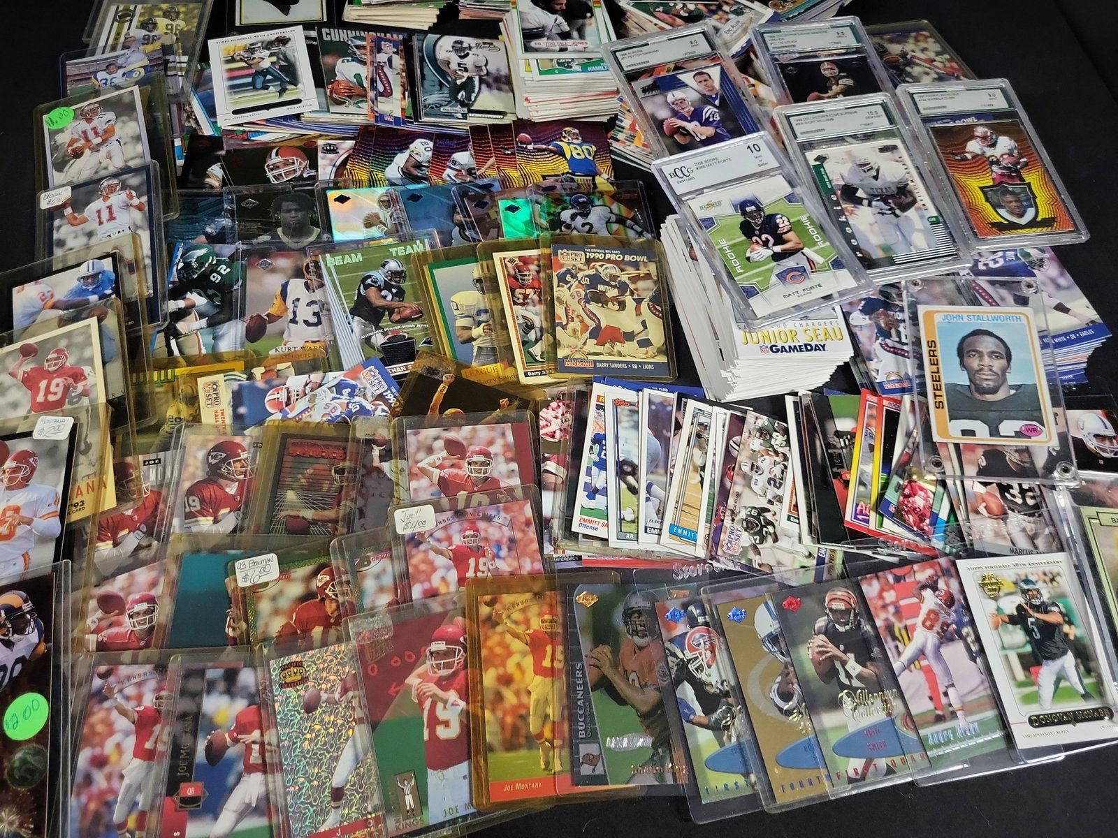 I03831 | A Collection of NFL Trading Cards Including Graded Rookie and Hall of Fame Players: BID PER WHAT YOU SEE IN THE PHOTO, NOT THE AI GENERATED TITLES AND DESCRIPTIONS! This collection of NFL trading cards spans the late 1970s through the late 2000s and features a variety of manufacturer