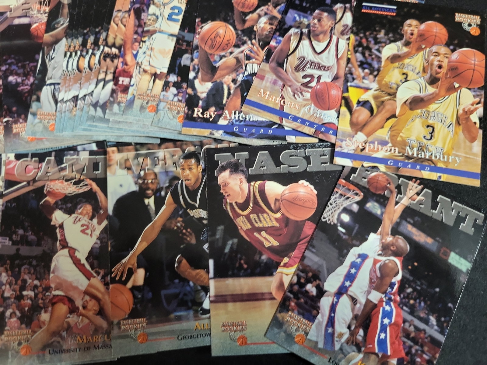I03801 | A Collection of 1990s Basketball Trading Cards Including 1996 Score Board Rookies: BID PER WHAT YOU SEE IN THE PHOTO, NOT THE AI GENERATED TITLES AND DESCRIPTIONS! This collection consists of multiple basketball trading cards primarily from the mid-1990s, focusing on collegiate and 
