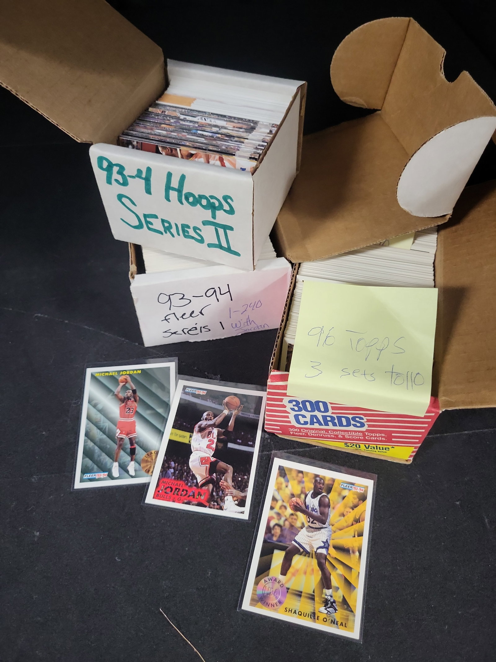 I03808 | A Collection of 1990s Basketball Trading Cards Including Fleer, Hoops, and Topps Sets: BID PER WHAT YOU SEE IN THE PHOTO, NOT THE AI GENERATED TITLES AND DESCRIPTIONS! An assortment of 1990s basketball trading cards from various manufacturers including Fleer, SkyBox Hoops, and Topps. Th