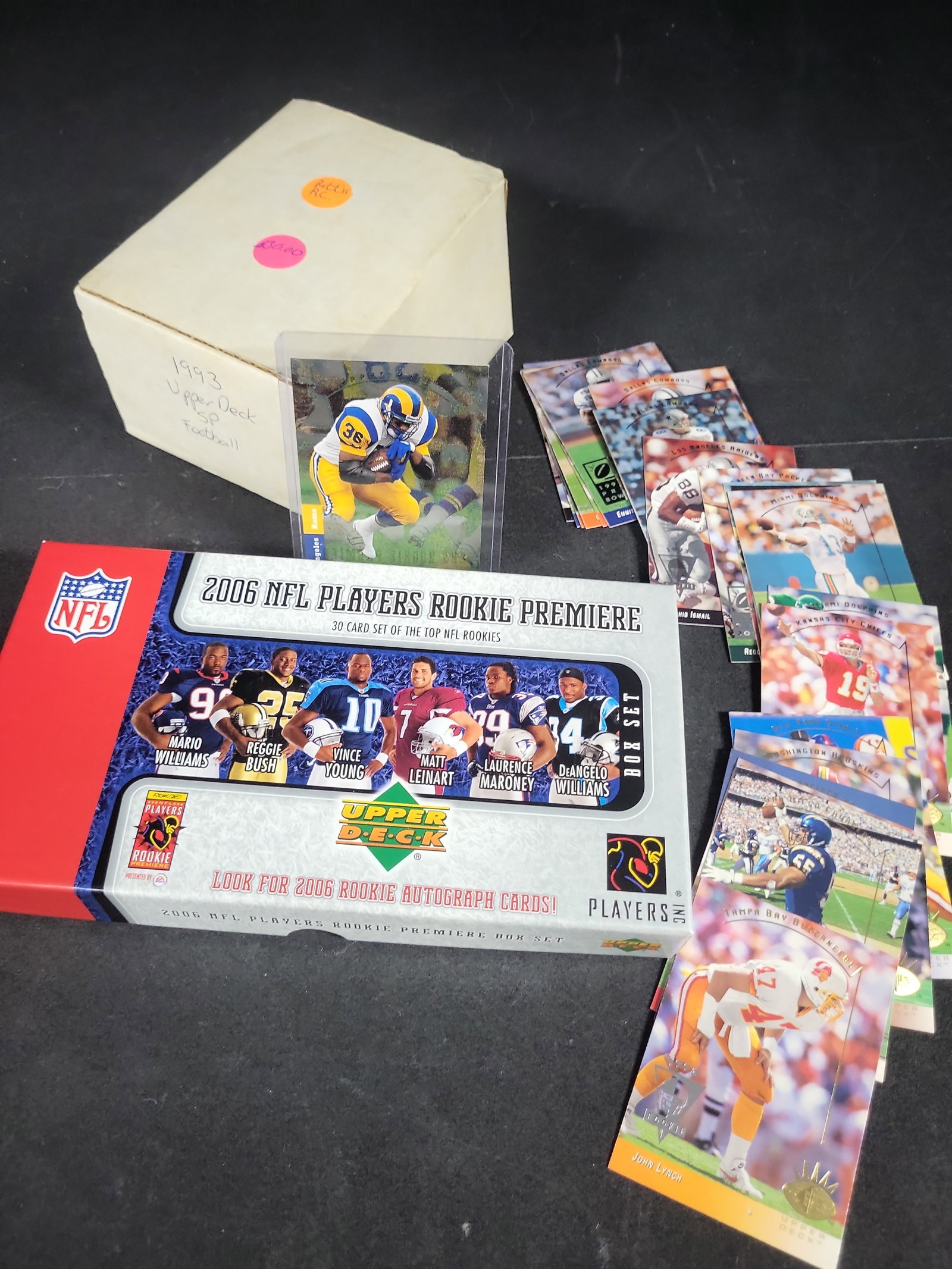 I03828 | A Collection of NFL Trading Cards Including 2006 Upper Deck Rookie Premiere Box Set and: BID PER WHAT YOU SEE IN THE PHOTO, NOT THE AI GENERATED TITLES AND DESCRIPTIONS! This lot features a collection of NFL football trading cards, primarily from the 1993 and 2006 seasons. The collection 