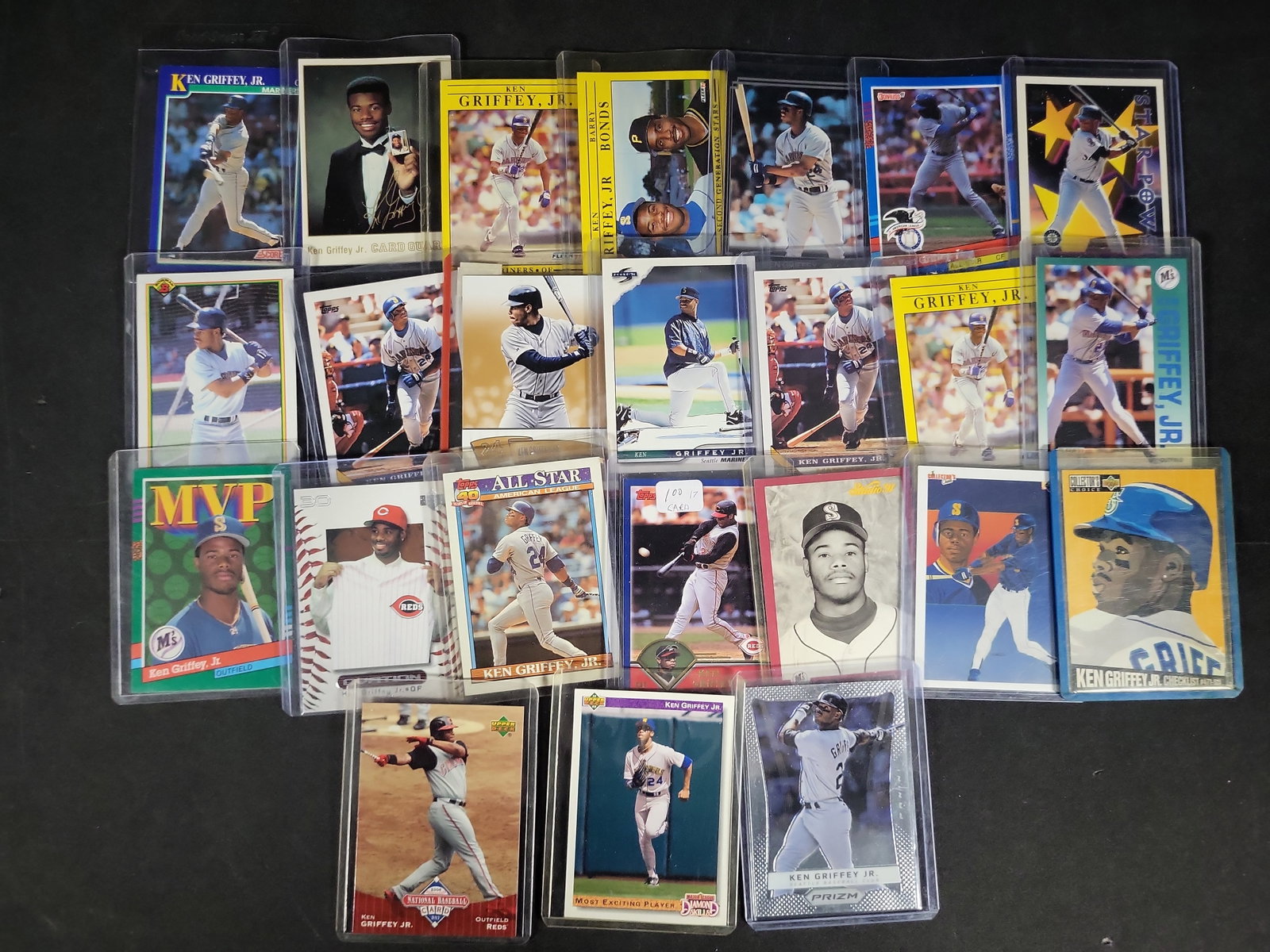 I03840 | A Collection of 24 Ken Griffey Jr. Baseball Cards Including Topps Upper Deck Fleer and: BID PER WHAT YOU SEE IN THE PHOTO, NOT THE AI GENERATED TITLES AND DESCRIPTIONS! This lot consists of twenty-four baseball cards primarily featuring Hall of Fame outfielder Ken Griffey Jr. The collect