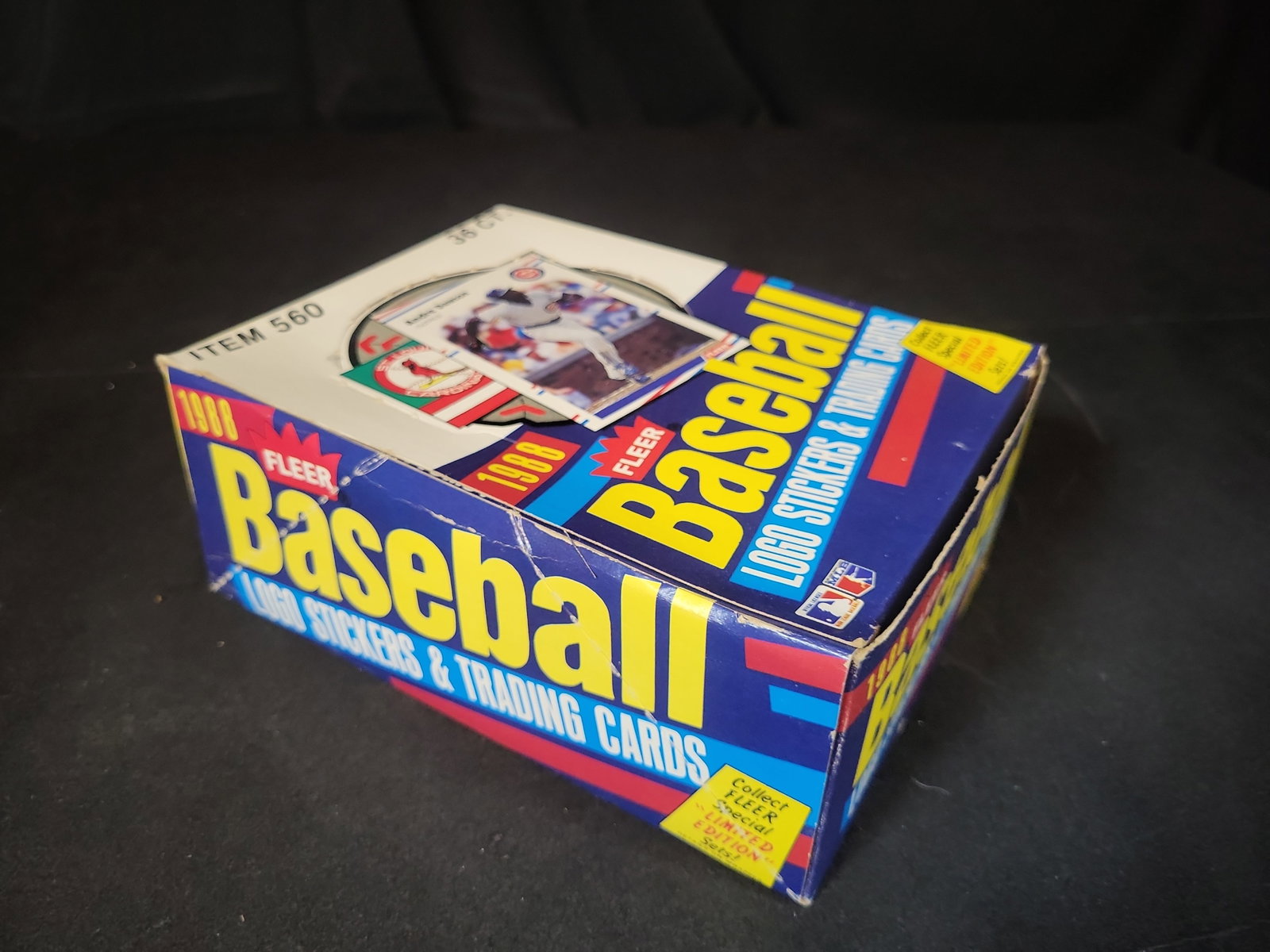 I03244 | A Collection of 1988 Fleer Baseball Unopened Wax Packs in Display Box: BID PER WHAT YOU SEE IN THE PHOTO, NOT THE AI GENERATED TITLES AND DESCRIPTIONS! This lot features a vintage 1988 Fleer Baseball wax pack display box containing several unopened wax packs. The display